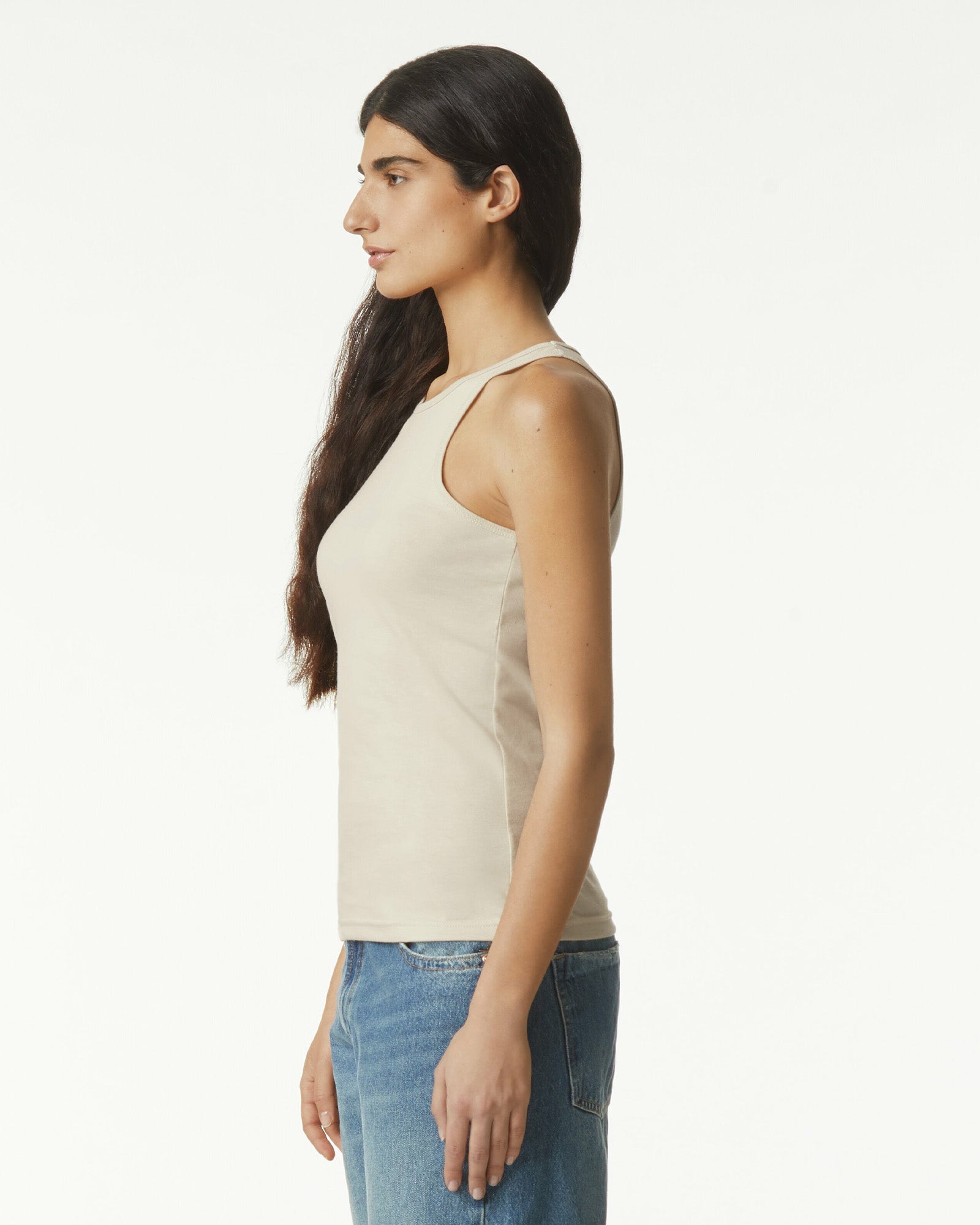 Female model wearing heather bone colour CVC Women's Racerneck Tank Top (side pose) -heather bone