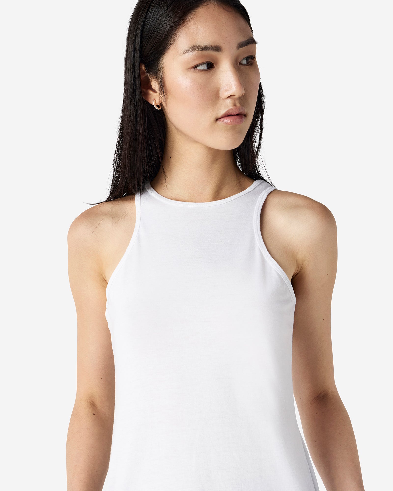 Close-up of a woman wearing a American Apparel Racerneck tank top, highlighting the sleek neckline and fitted silhouette - white