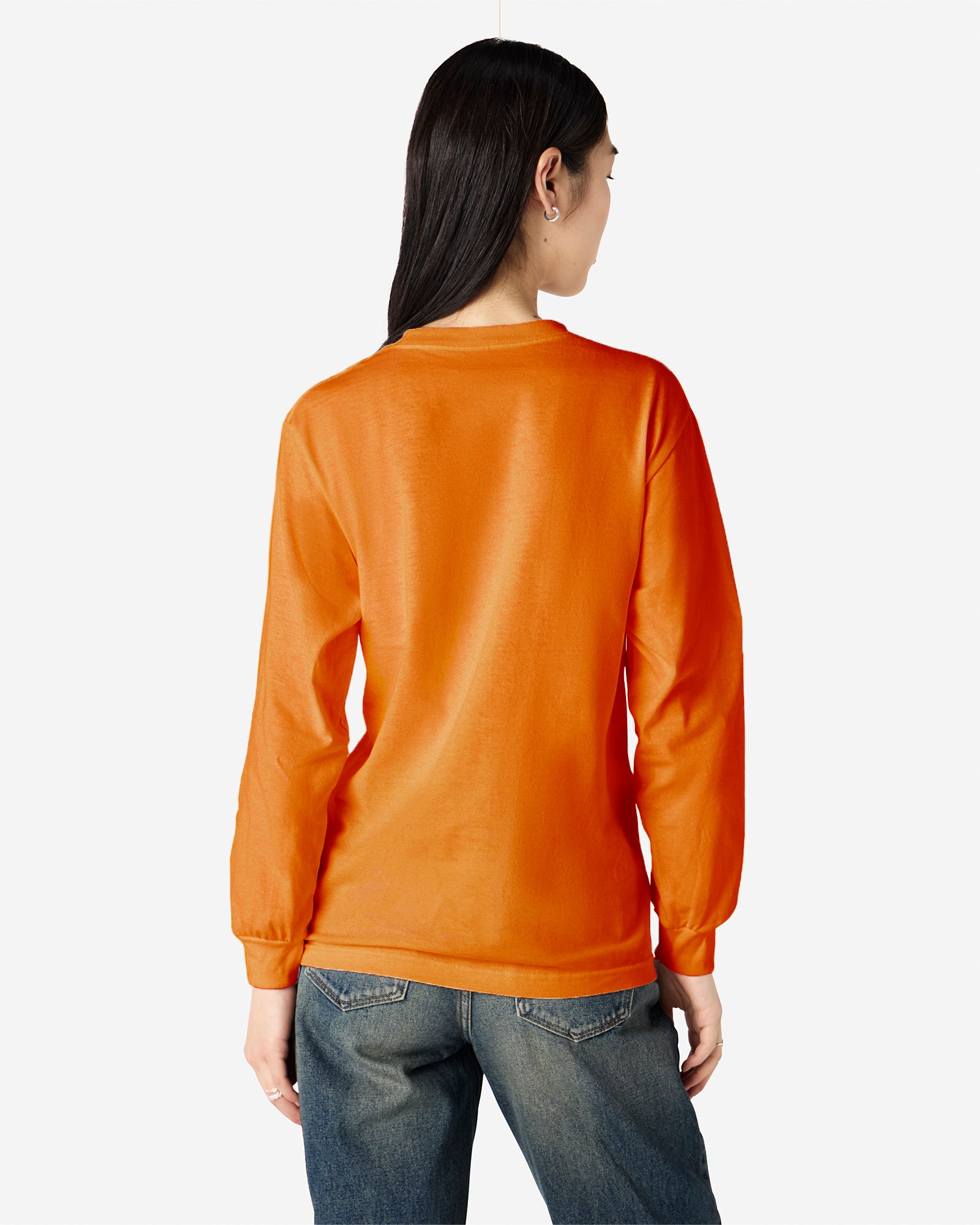 front view of a female Model wearing a Heather Orange Heavyweight Unisex Long Sleeve Crew Neck Tee, paired with blue jeans, standing against a plain background (back pose) -orange