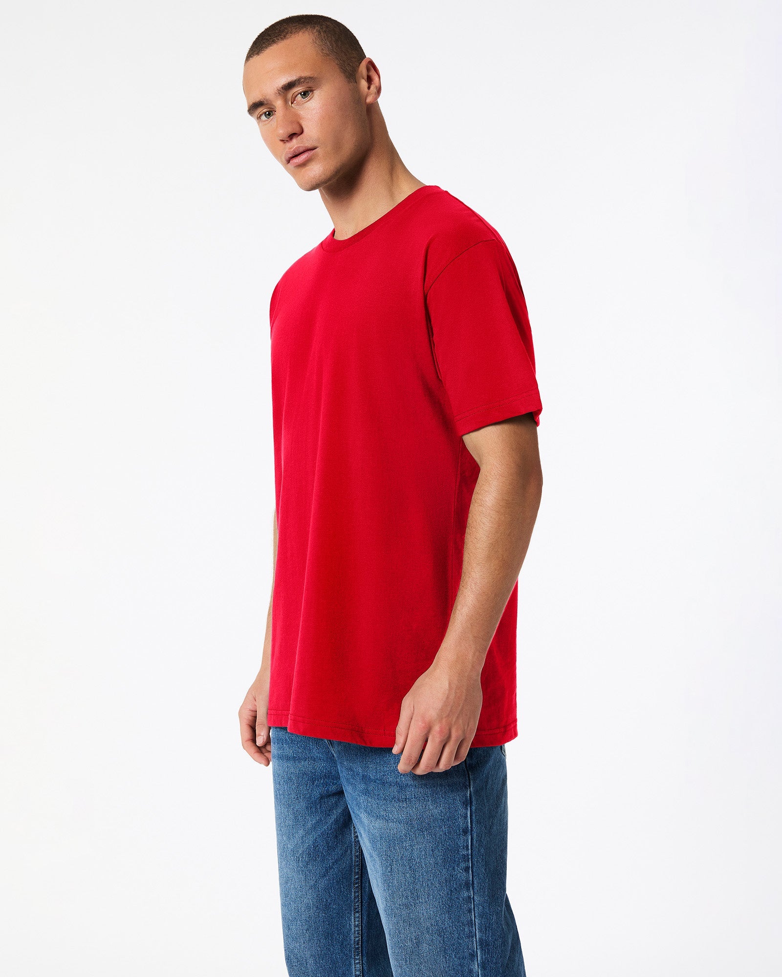 Male model wearing American Apparel Powder Red Colour Fine Jersey Unisex Short Sleeve Crew Neck Tee- side pose