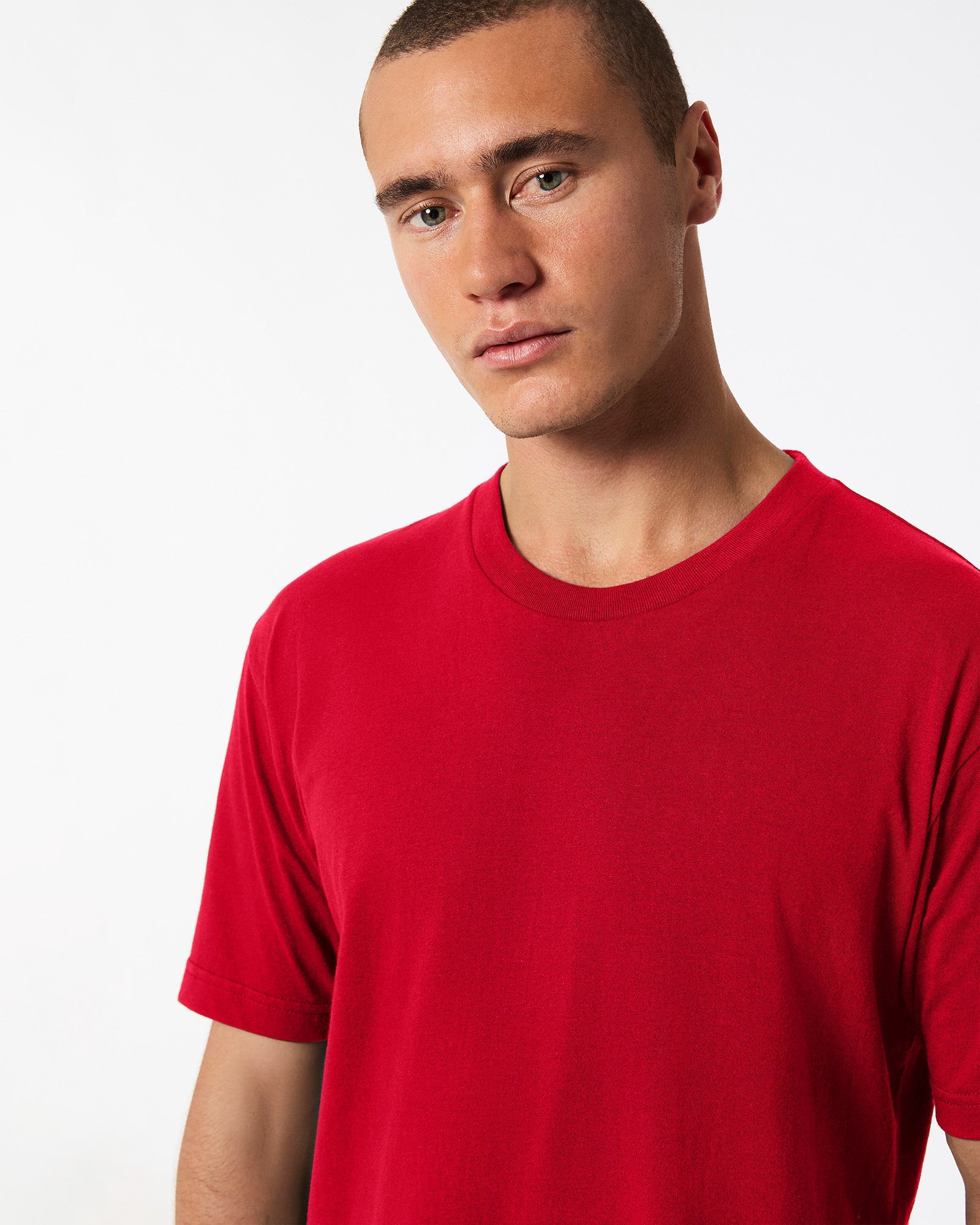 Male model wearing American Apparel Powder Red Colour Fine Jersey Unisex Short Sleeve Crew Neck Tee (half front pose) -red