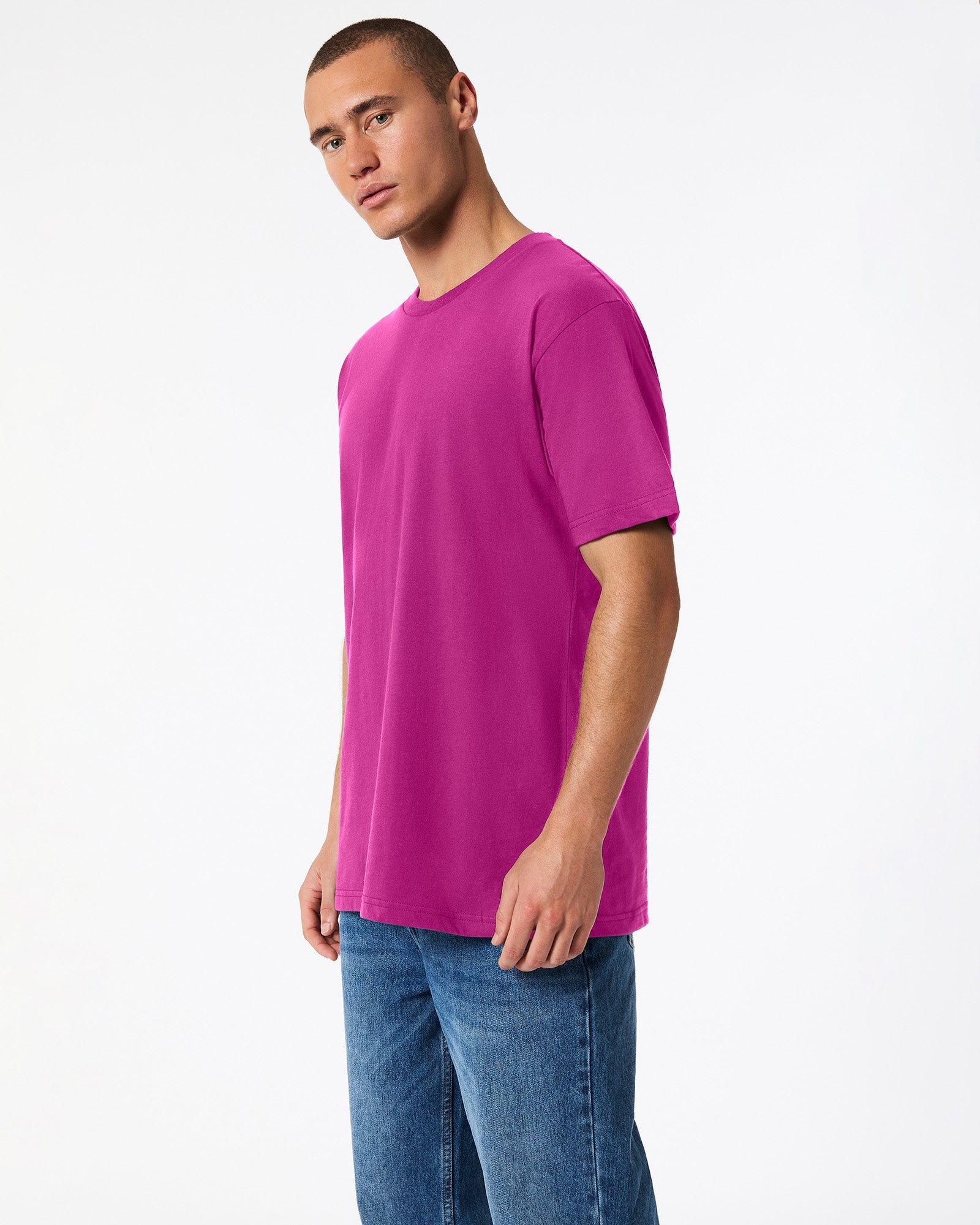 Male model wearing American Apparel Powder Super pink Colour Fine Jersey Unisex Short Sleeve Crew Neck Tee (side pose) -super pink
