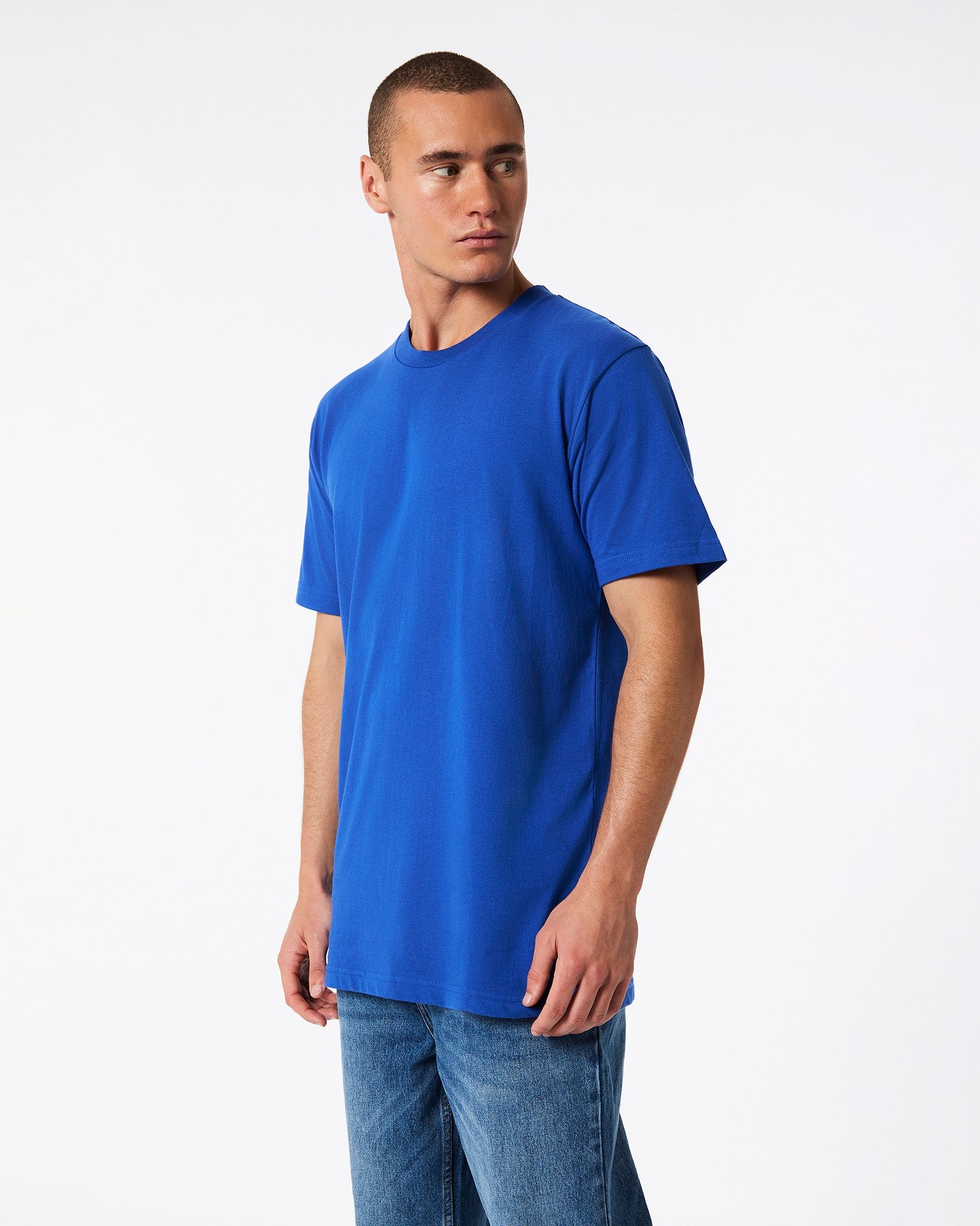 Male model wearing American Apparel Powder Royal Blue Colour Fine Jersey Unisex Short Sleeve Crew Neck Tee (side pose) -royal blue