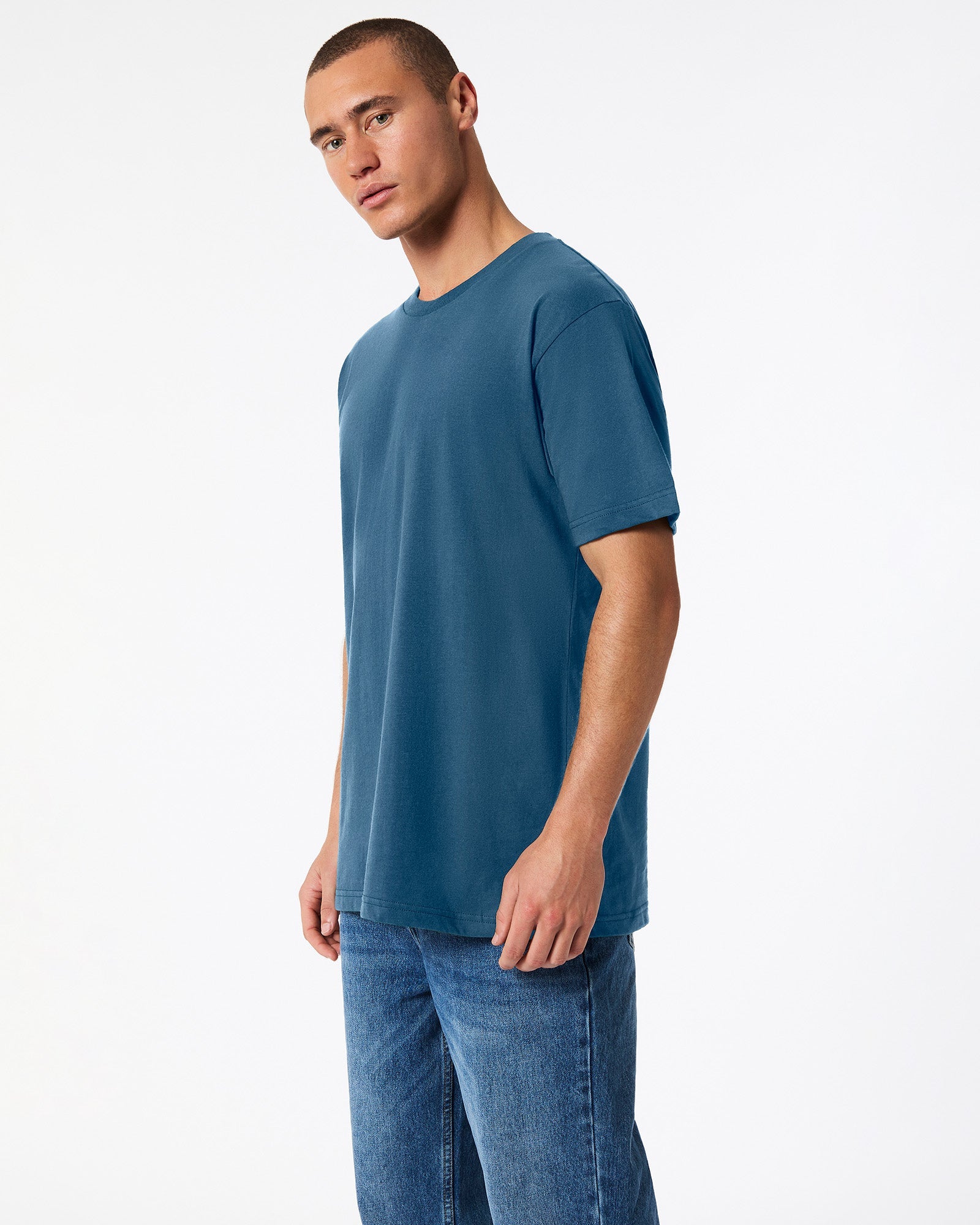 Male model wearing American Apparel Powder sea Blue Colour Fine Jersey Unisex Short Sleeve Crew Neck Tee (side pose) -sea blue