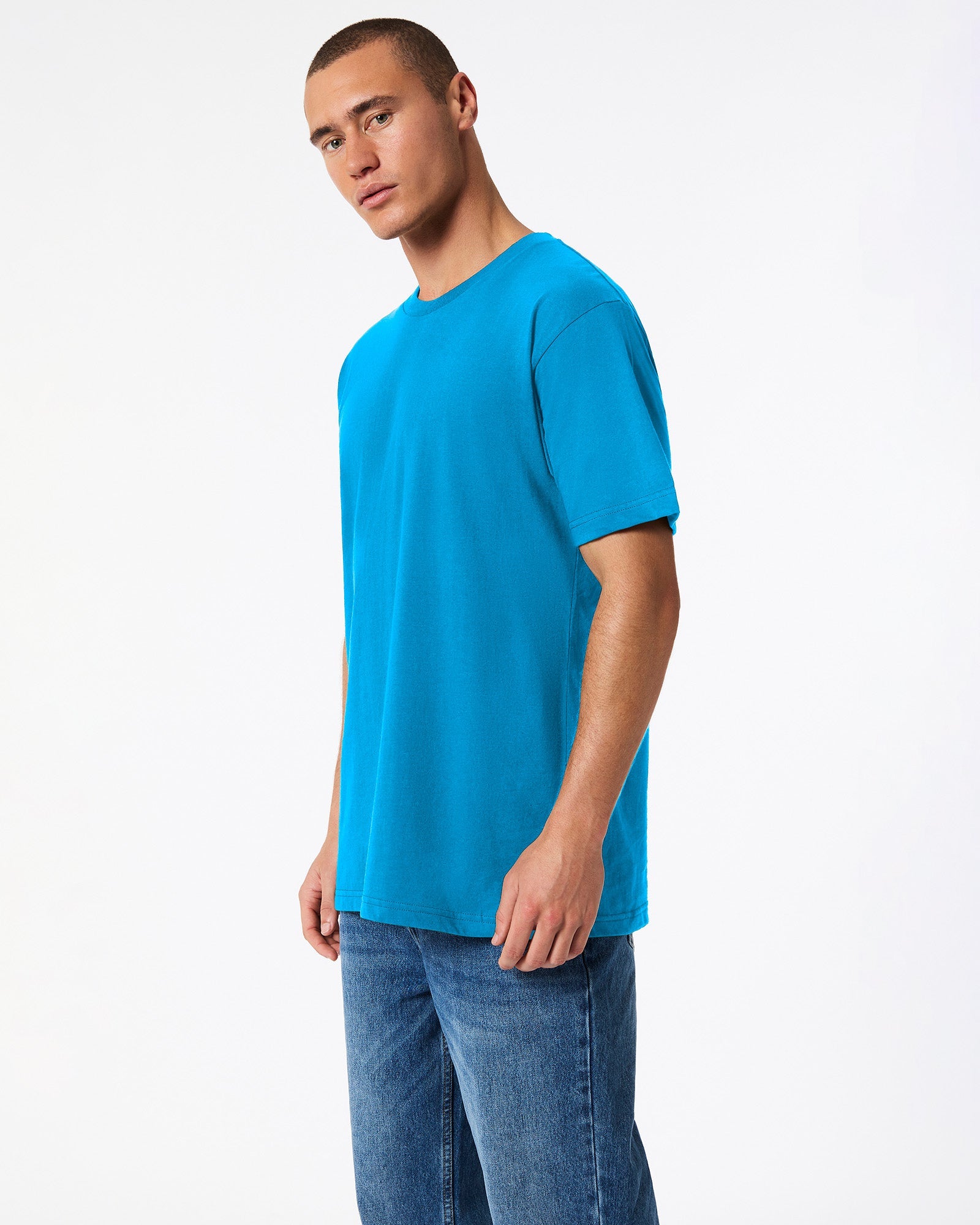 Male model wearing American Apparel Powder teal Colour Fine Jersey Unisex Short Sleeve Crew Neck Tee (side pose) -teal