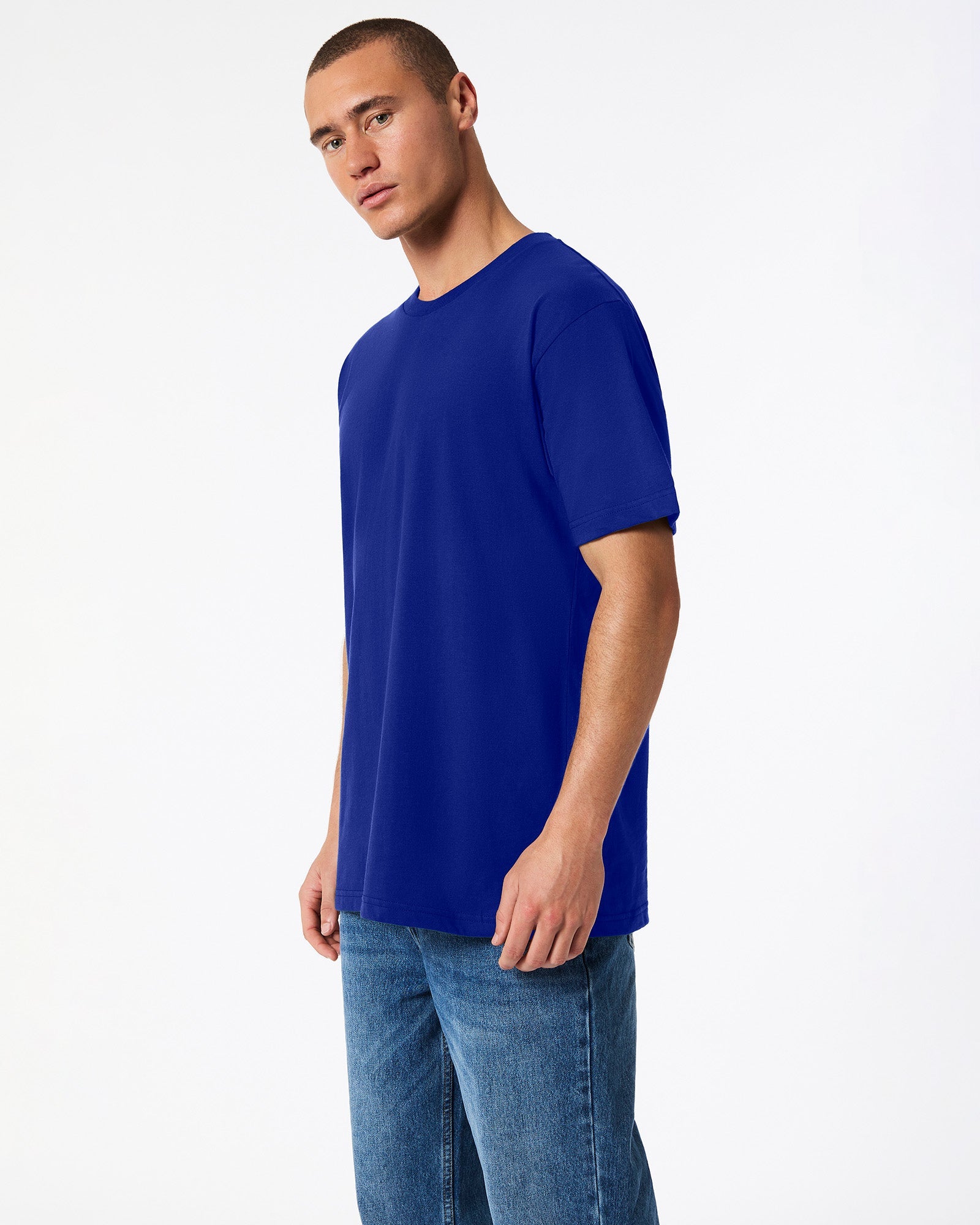 male model wearing Lapis colour Fine Jersey Unisex Crew Neck Tee (side pose) -lapis