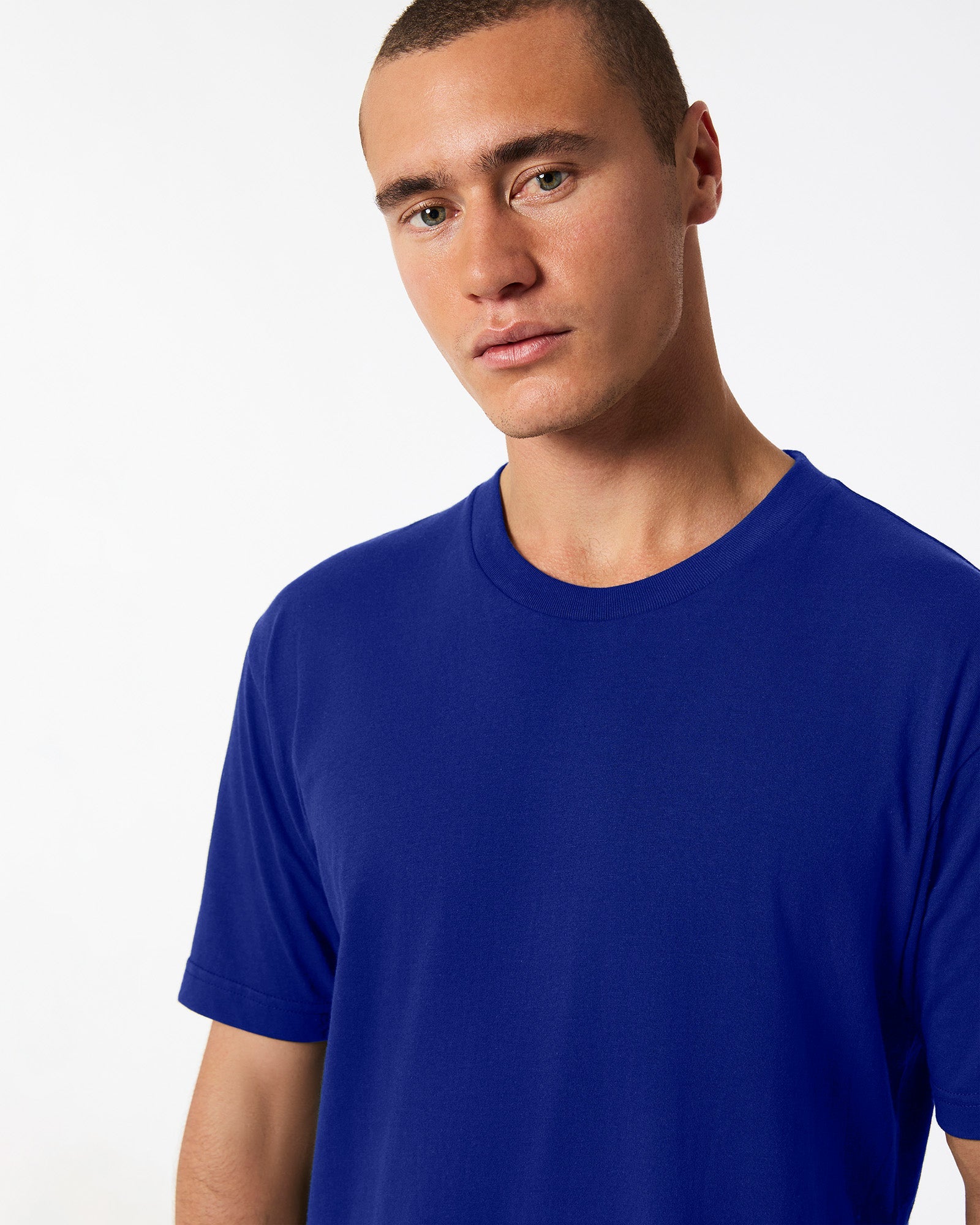 male model wearing Lapis colour Fine Jersey Unisex Crew Neck Tee (half front pose) -lapis