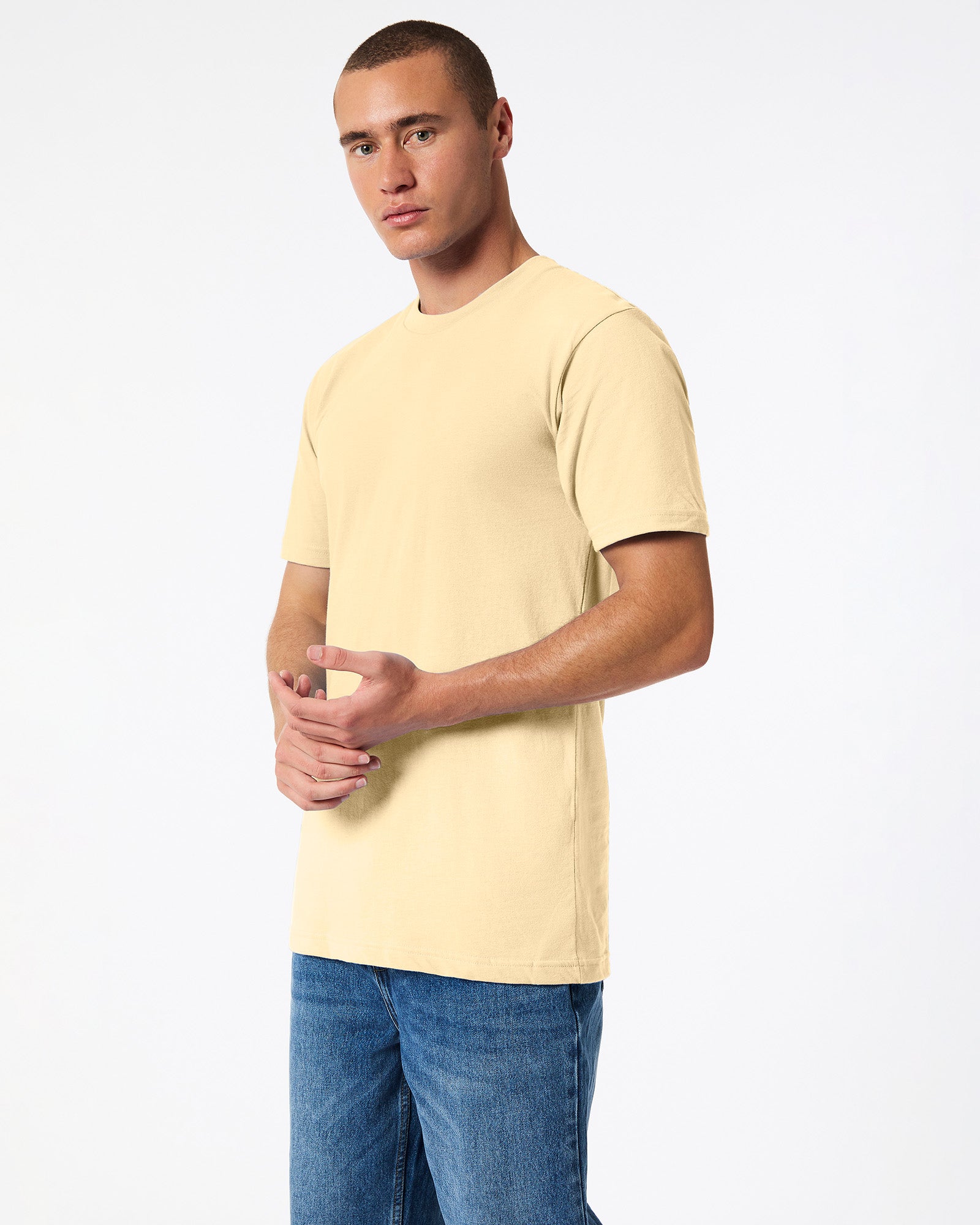 Male mode wearing cream colour American Apparel Fine jersey Unisex Short Sleeve Crew Neck Tee (side pose) -cream