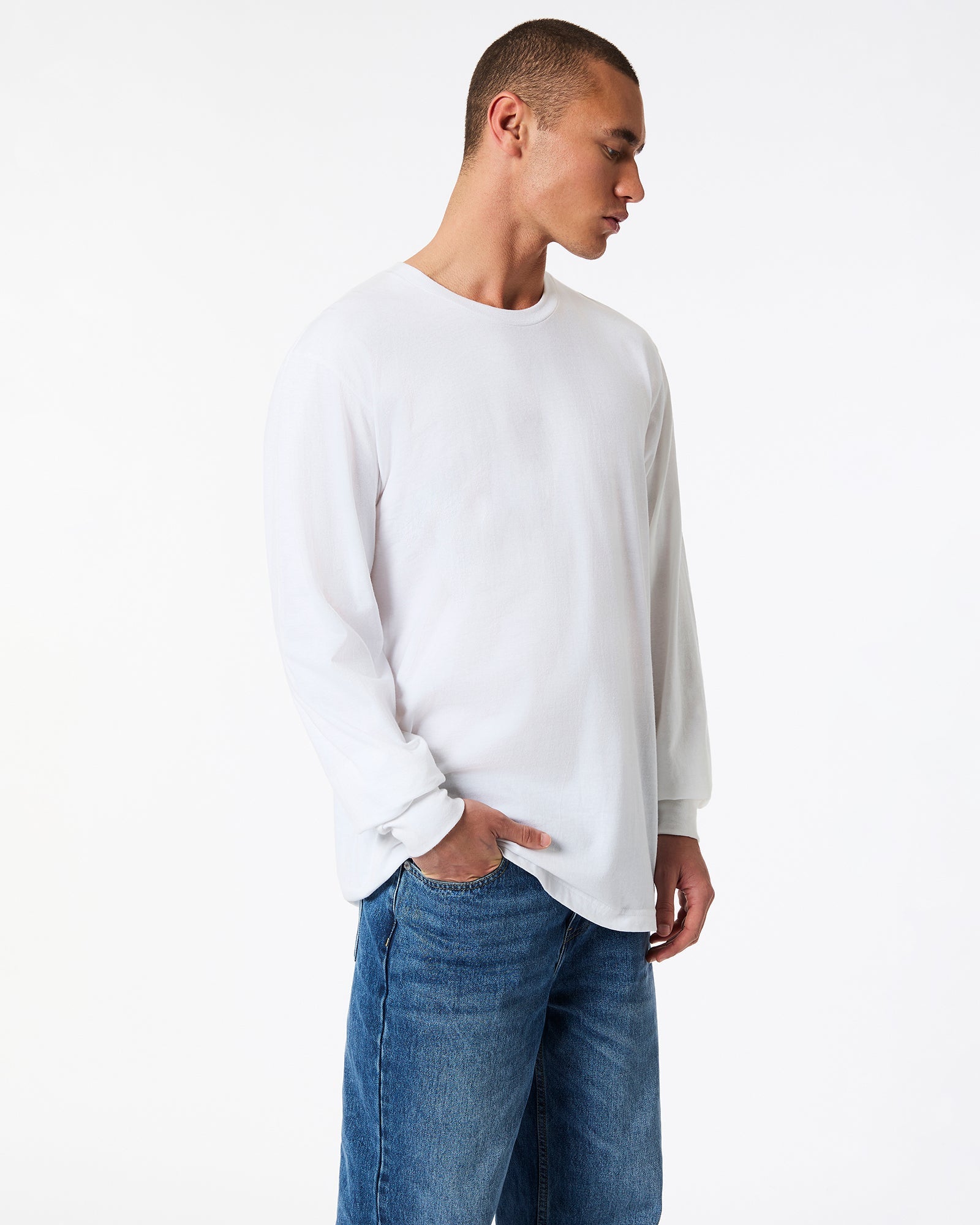 male model wearing American Apparel white Colour Fine Jersey Unisex Long Sleeve Crew Neck Tee (side pose) -white