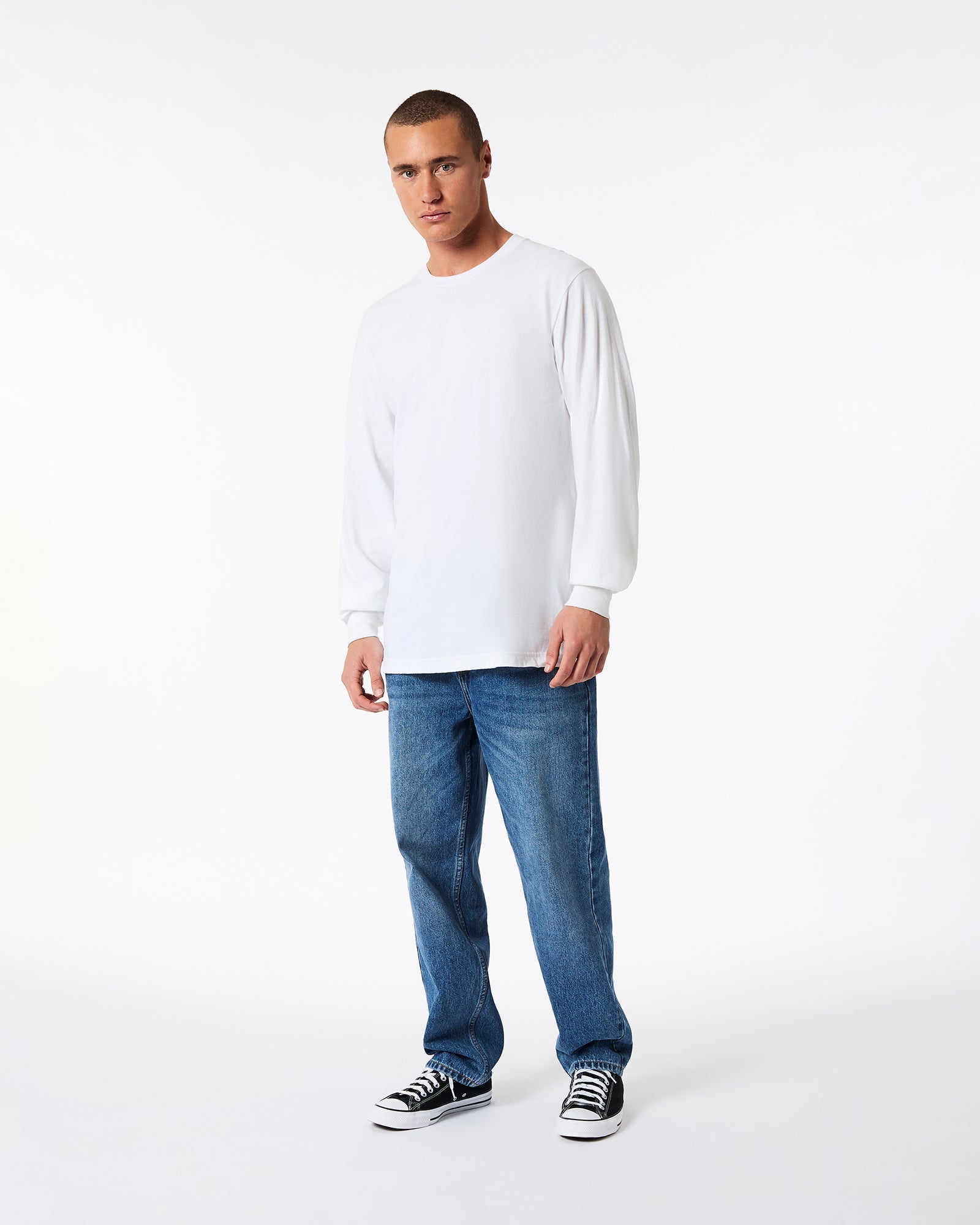 A male model wearing American Apparel white Colour Fine Jersey Unisex Long Sleeve Crew Neck Tee (Front pose) -white