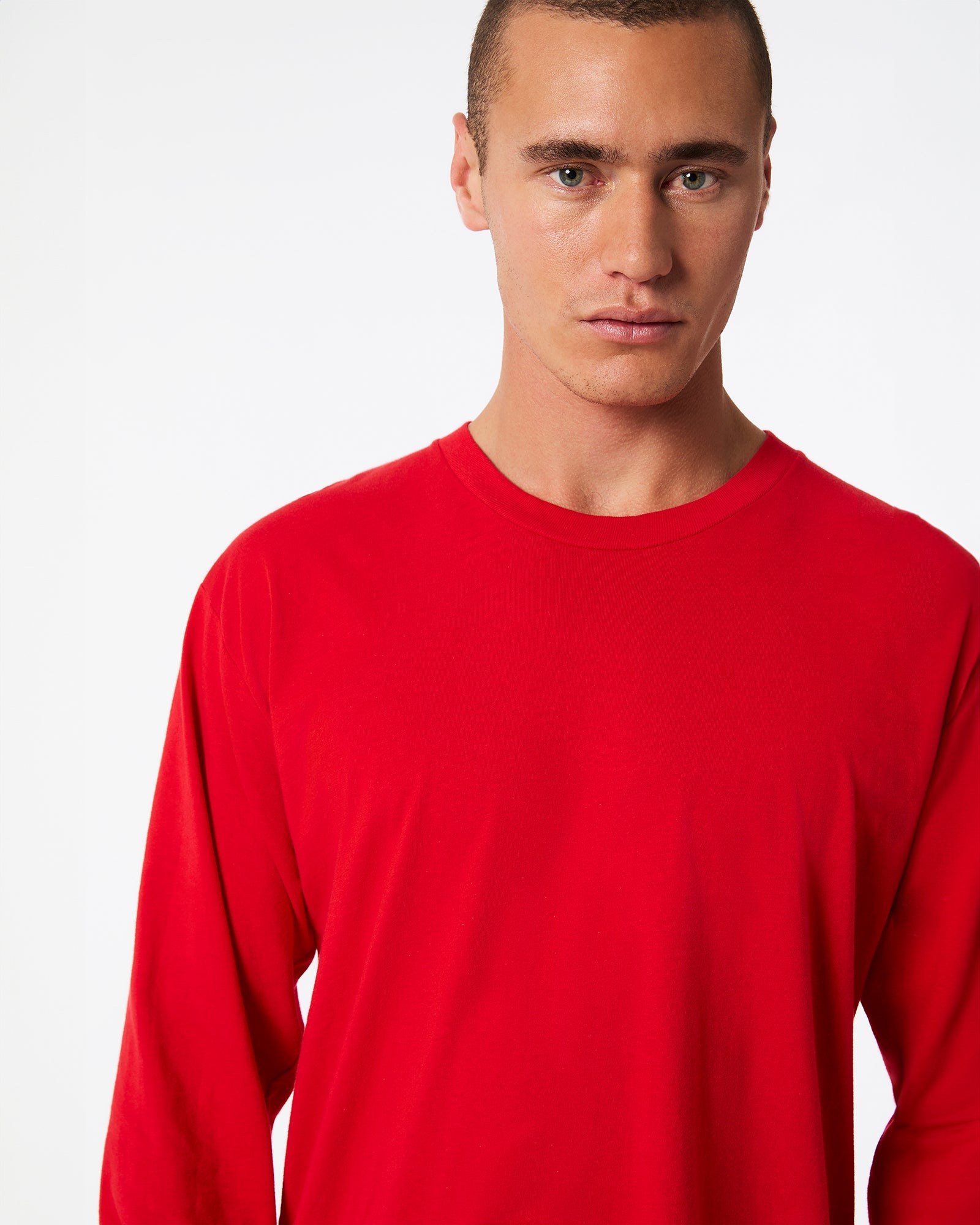 male model wearing American Apparel Red Colour Fine Jersey Unisex Long Sleeve Crew Neck Tee (half Front pose) -red