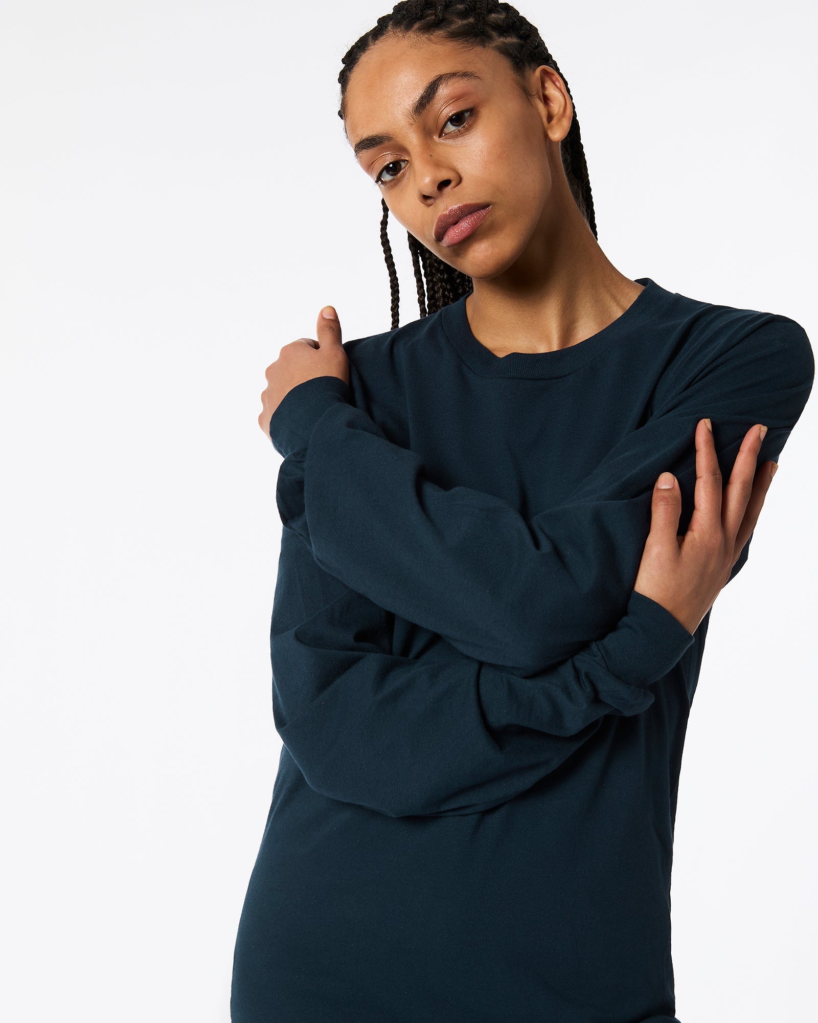 Female model wearing American Apparel Navy Colour Fine Jersey Unisex Long Sleeve Crew Neck Tee (cross hands pose) -navy