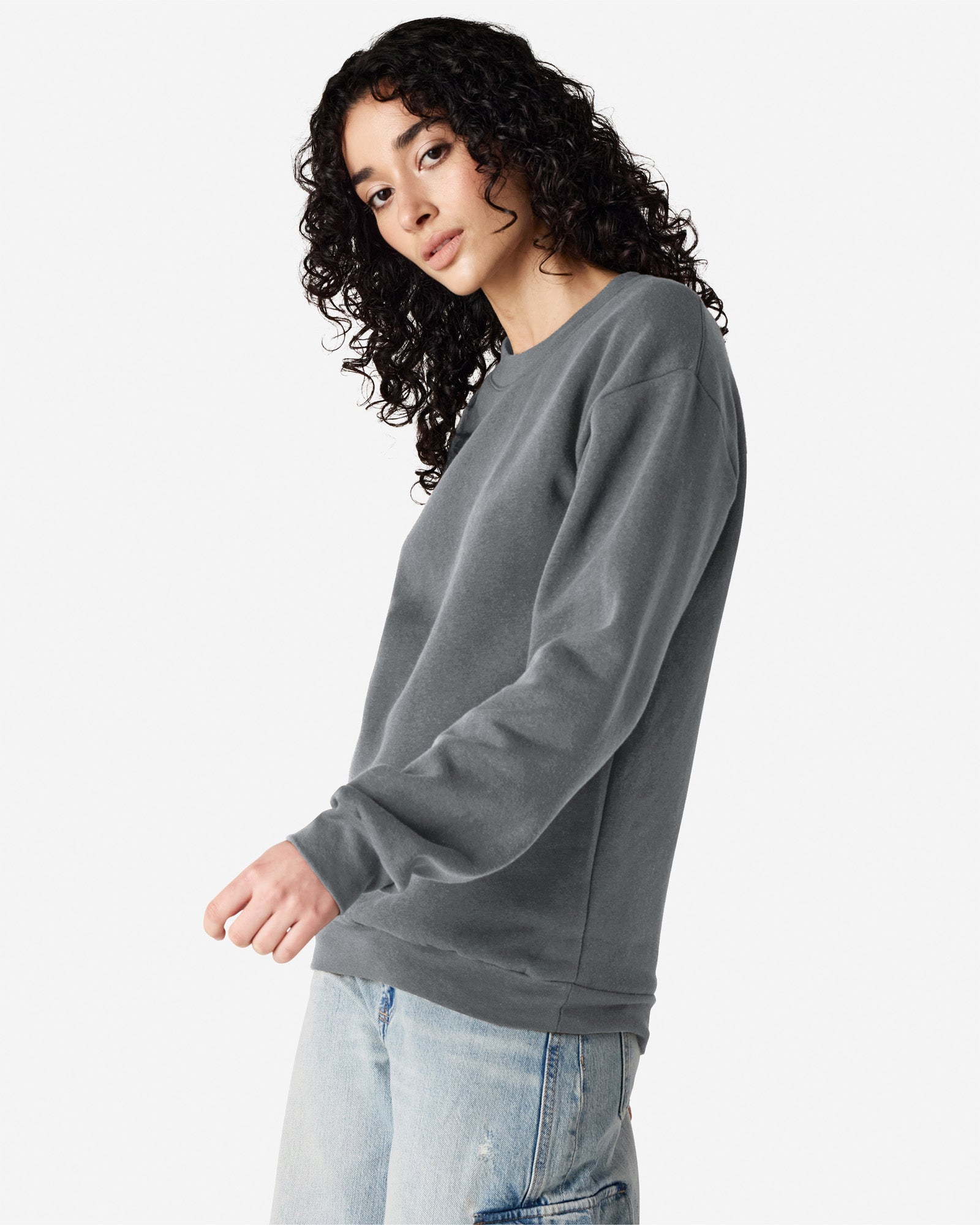 Female model wearing a Reflex Unisex Crewneck Sweatshirt (side front pose) -asphalt