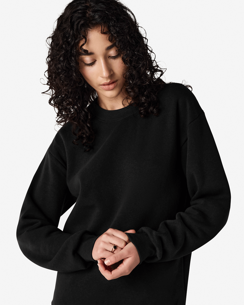 Female model wearing a Reflex Unisex Crewneck Sweatshirt (front pose) -black