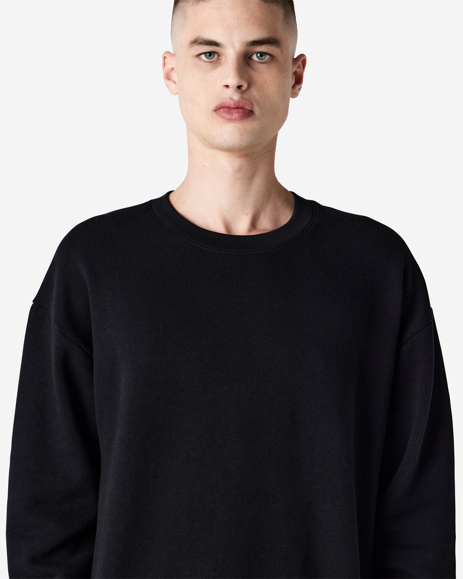 Male model wearing a Reflex Unisex Crewneck Sweatshirt (front pose) -black