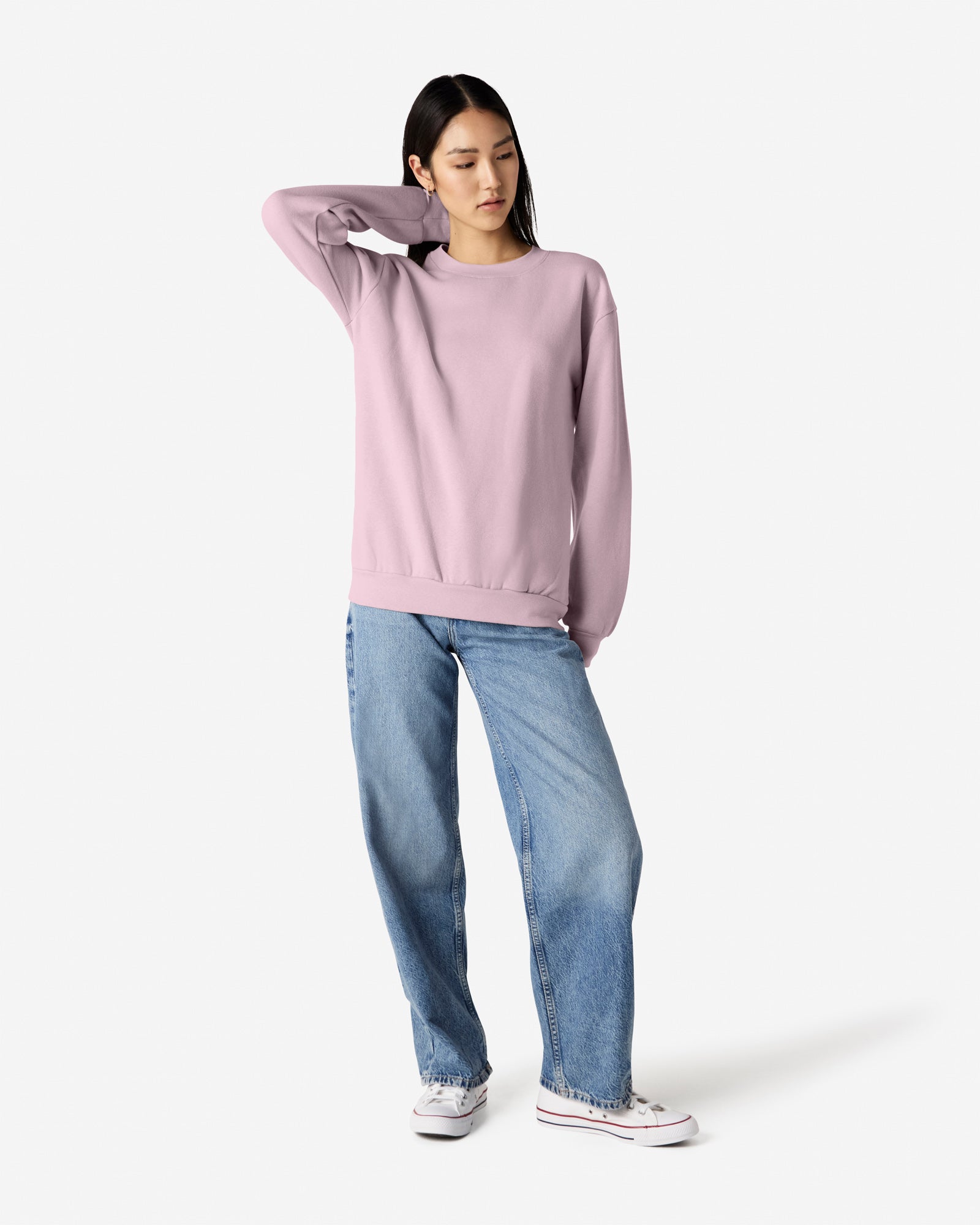 Female model wearing a Reflex Unisex Crewneck Sweatshirt (front pose) -blush