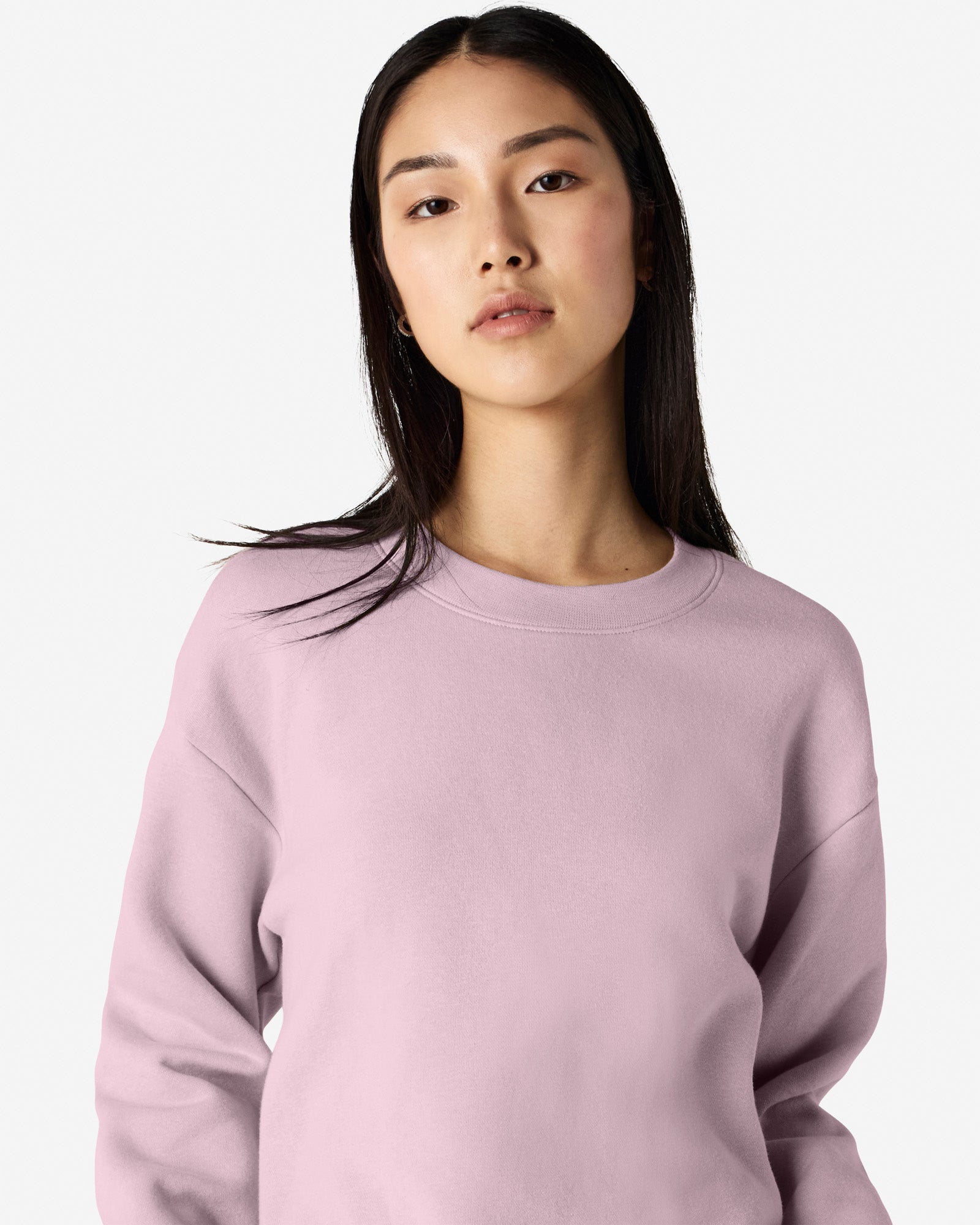 Female model wearing a Reflex Unisex Crewneck Sweatshirt (front pose) -blush