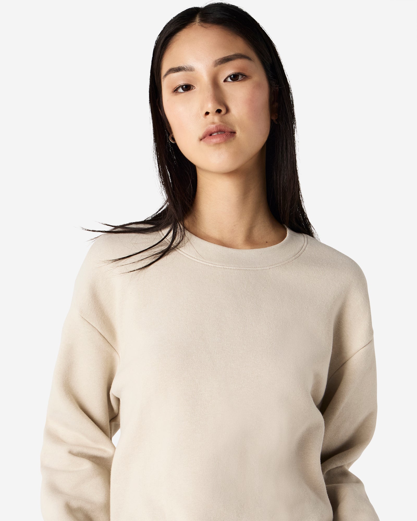 Female model wearing a Reflex Unisex Crewneck Sweatshirt (front pose) -bone