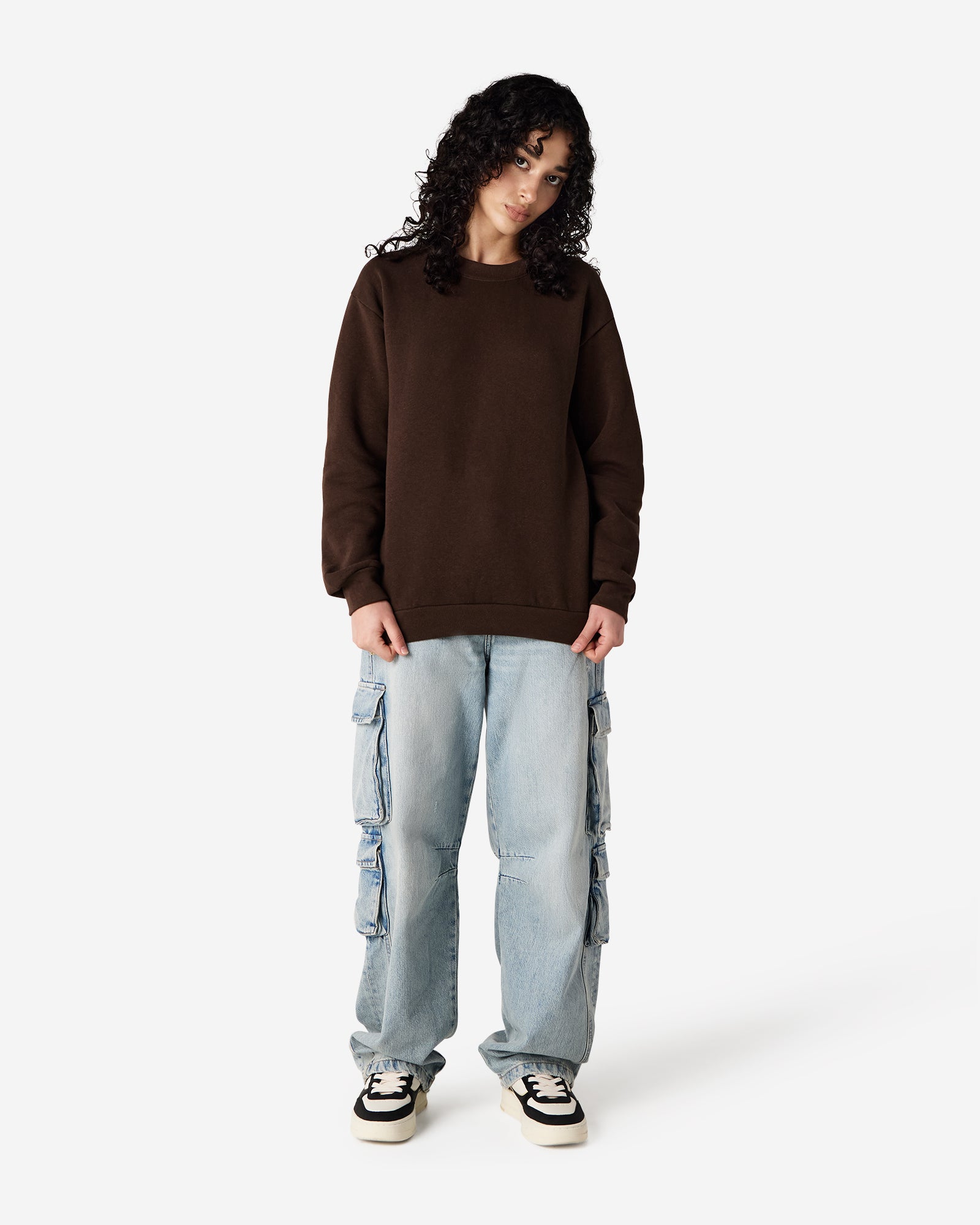 Female model wearing a Reflex Unisex Crewneck Sweatshirt (front pose) -brown