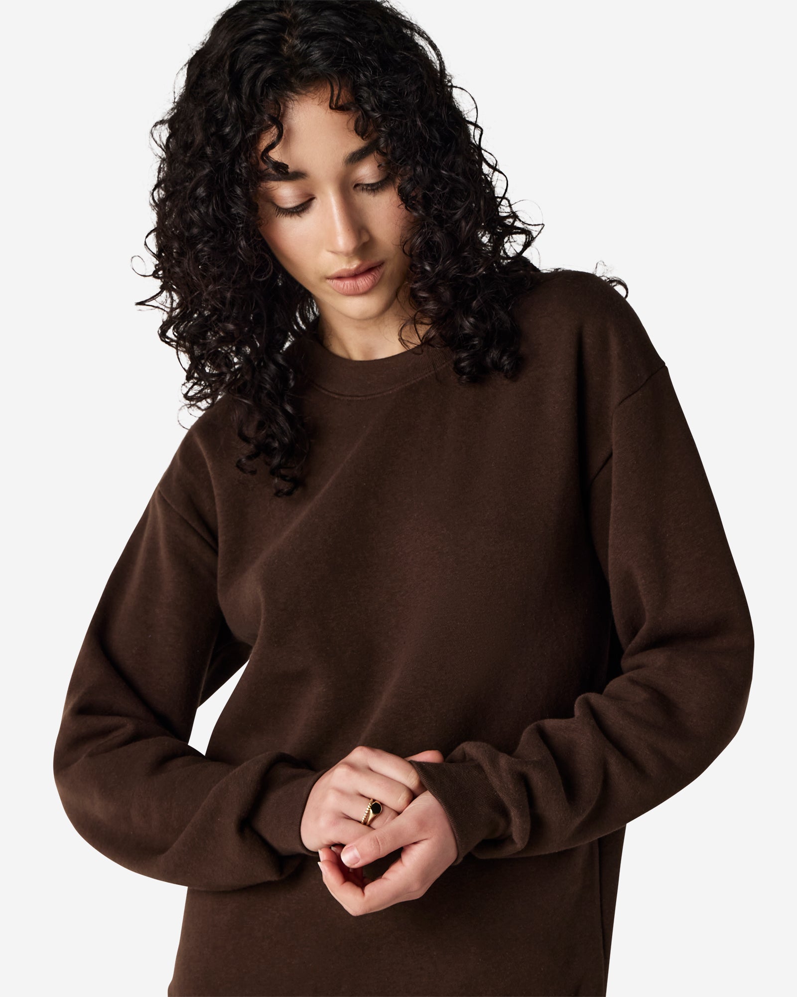 Female model wearing a Reflex Unisex Crewneck Sweatshirt (front pose) -brown