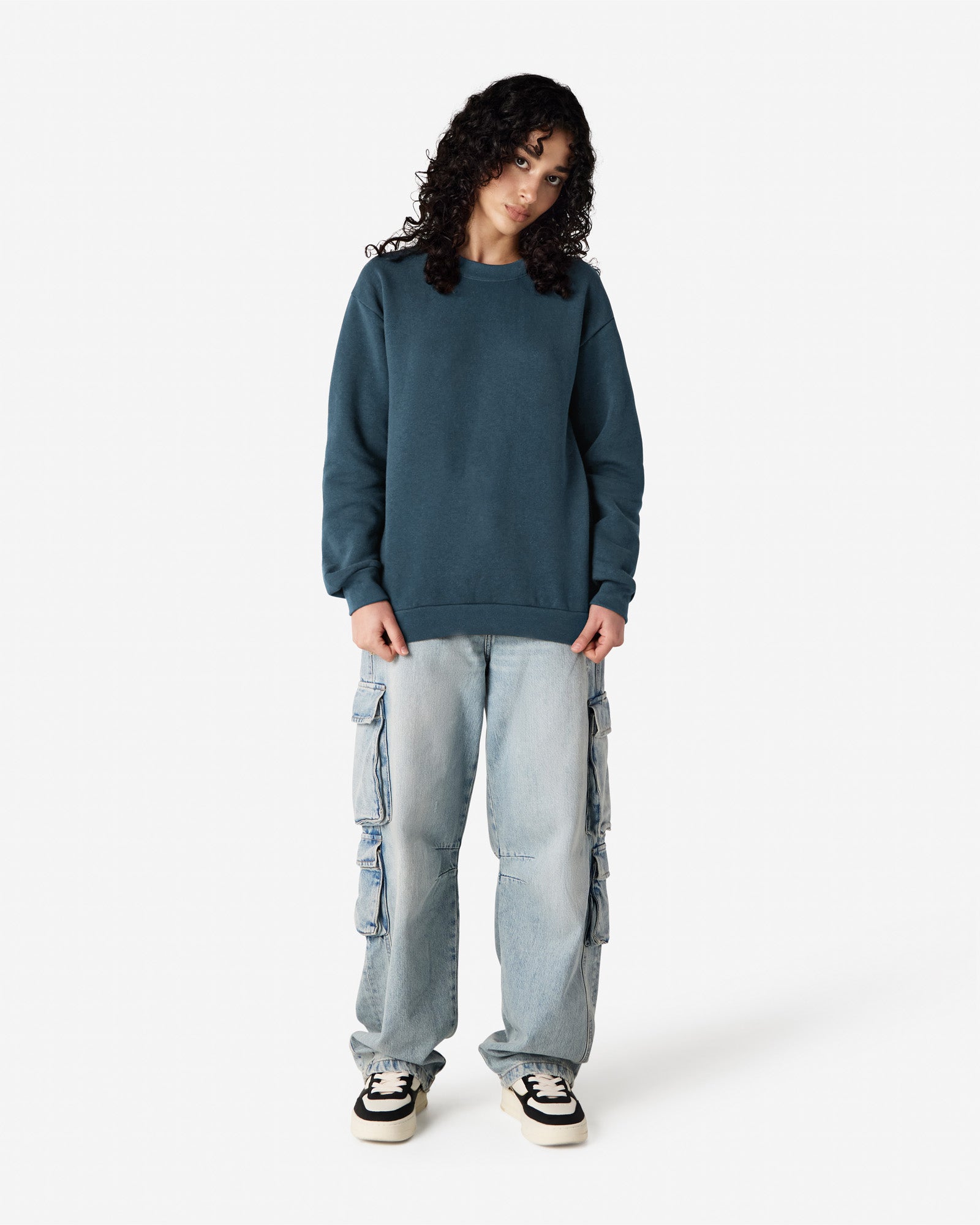 Female model wearing a Reflex Unisex Crewneck Sweatshirt (front pose) -sea blue