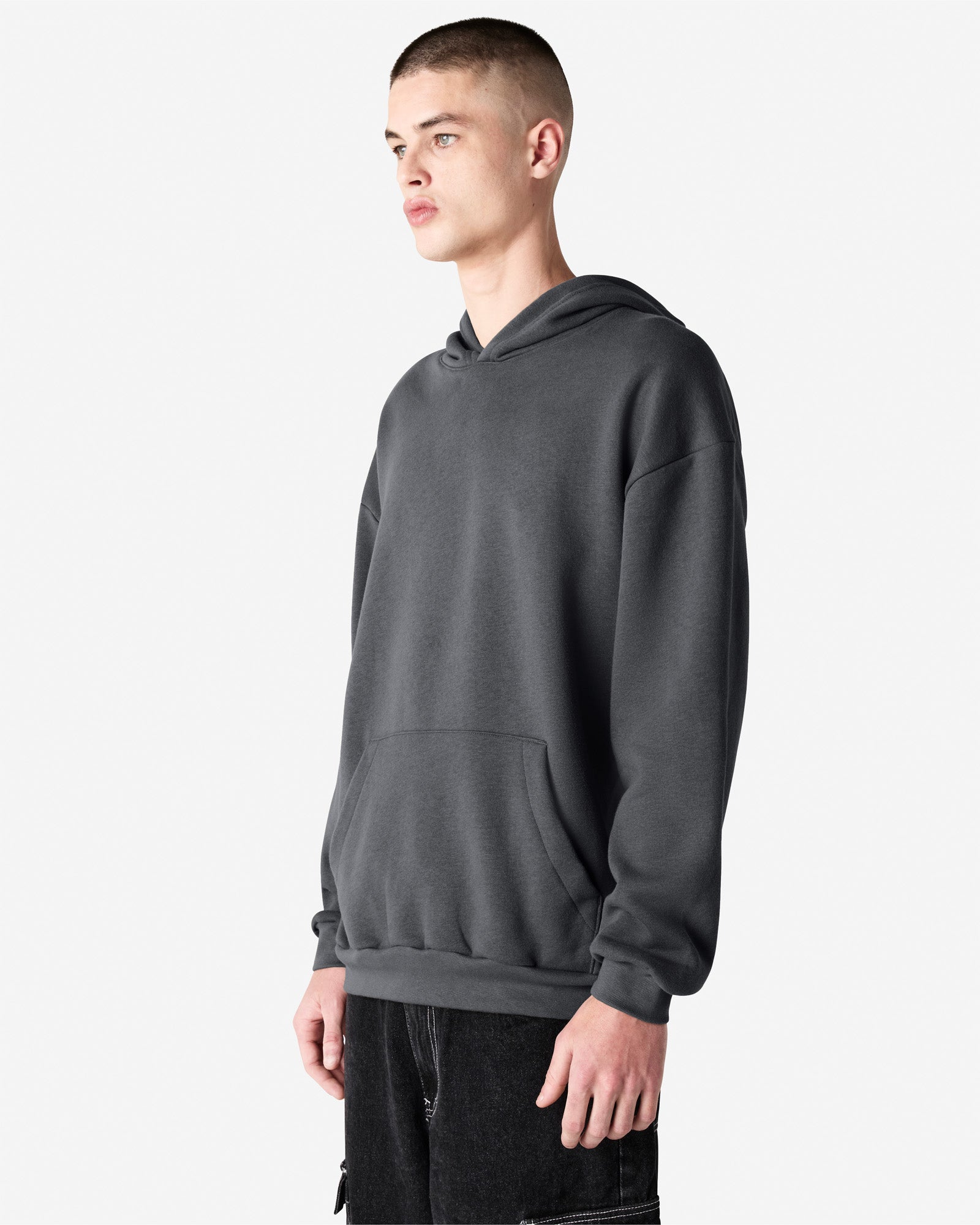 Male model wearing a Reflex Unisex Hooded Sweatshirt (side pose) -asphalt