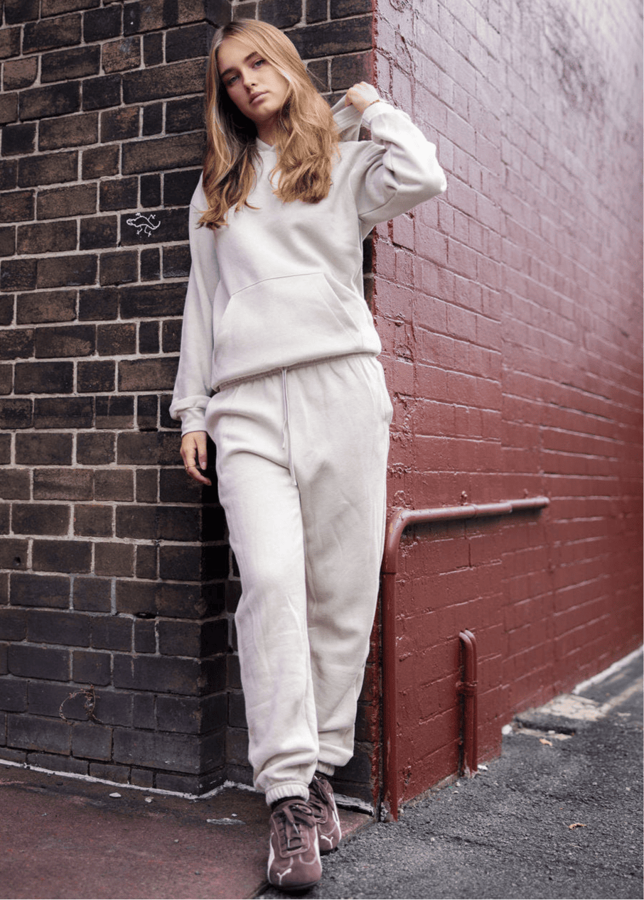 Female model wearing a Reflex Unisex Hooded Sweatshirt (front pose) -bone