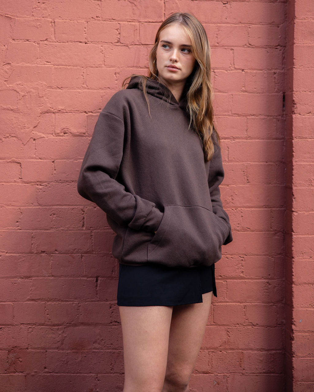 Male model wearing a Reflex Unisex Hooded Sweatshirt (front pose) -Brown