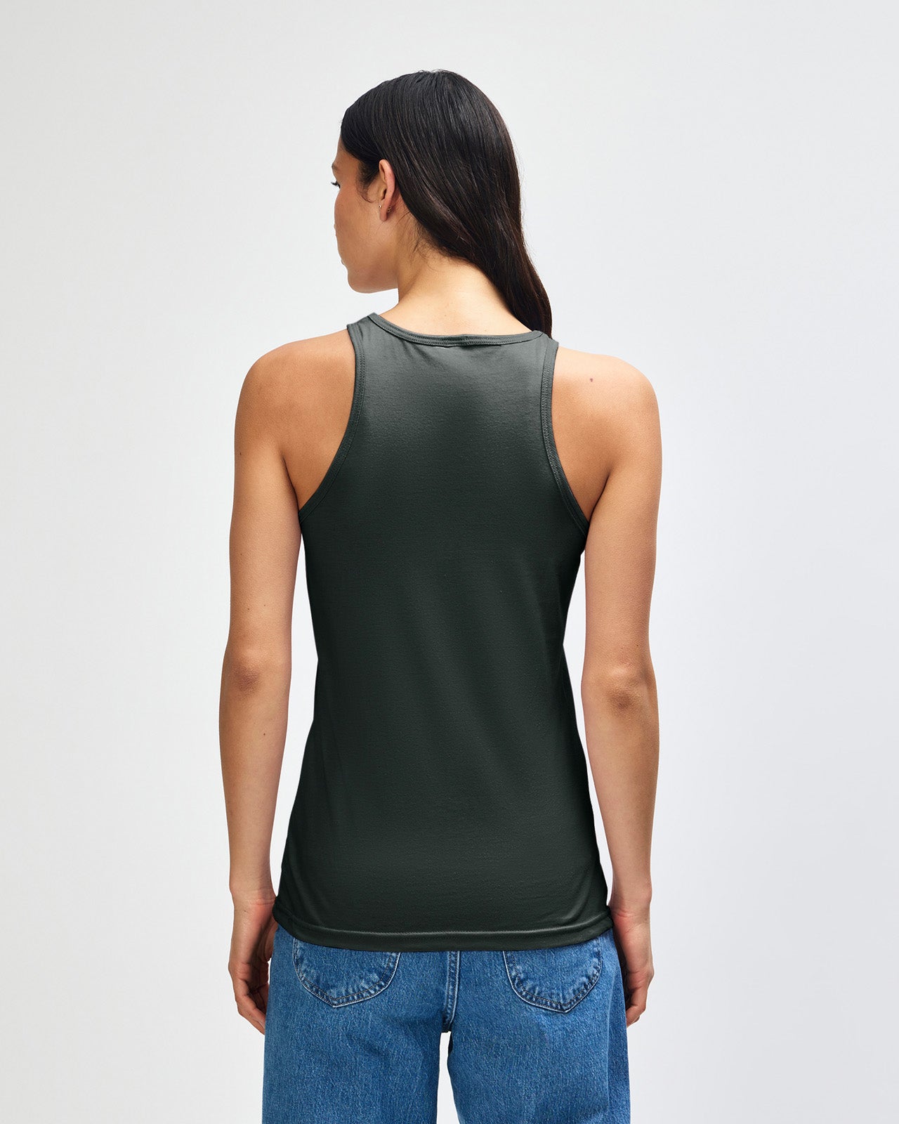 Front-facing view of a woman wearing the American Apparel Racerneck tank top, paired with light blue denim for a clean, minimalist look - heather charcoal