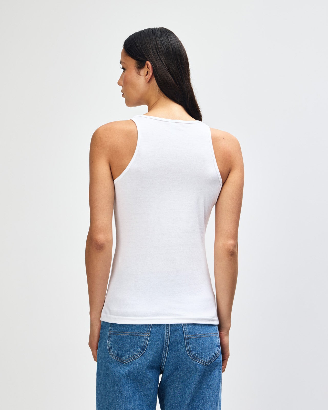 Female model wearing white colour American Apparel Fine Jersey Unisex Tank Top (front pose) -white