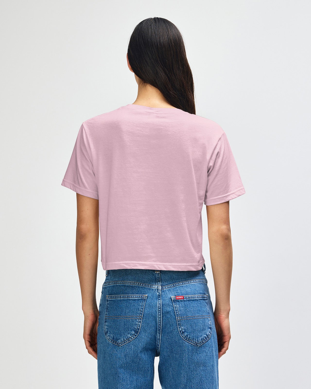 Female model wearing an American Apparel Fine Jersey Women's Boxy Tee in Black, paired with blue jeans, standing against a plain background (front pose) -blush