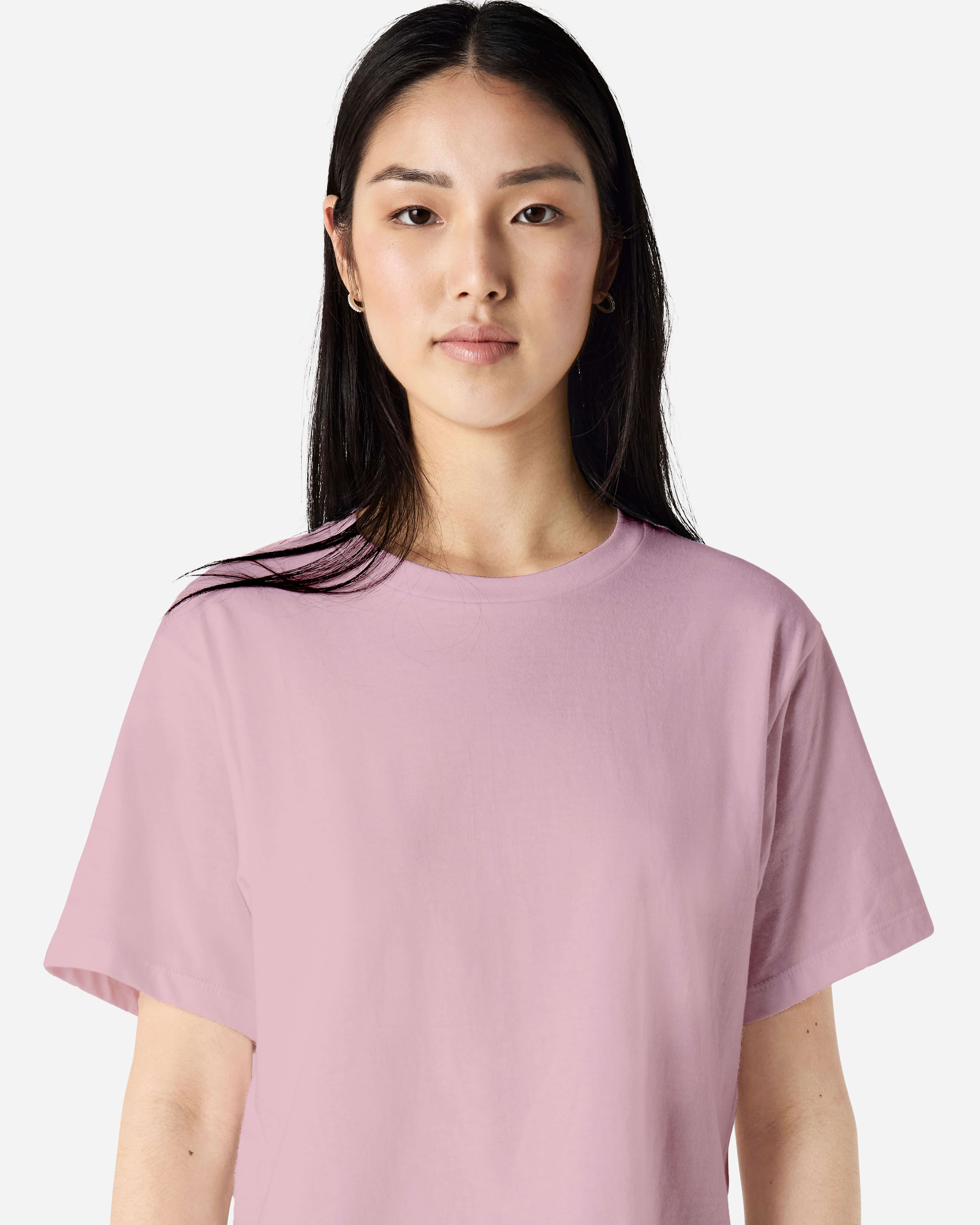 Female model wearing an American Apparel Fine Jersey Women's Boxy Tee in blush, paired with blue jeans, standing against a plain background (front pose) -blush