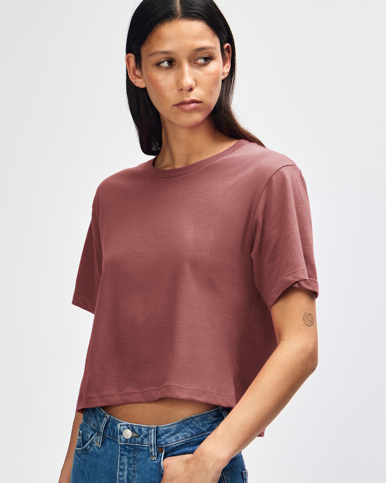 Female model wearing an American Apparel Fine Jersey Women's Boxy Tee in canyon, paired with blue jeans, standing against a plain background (front pose) -canyon