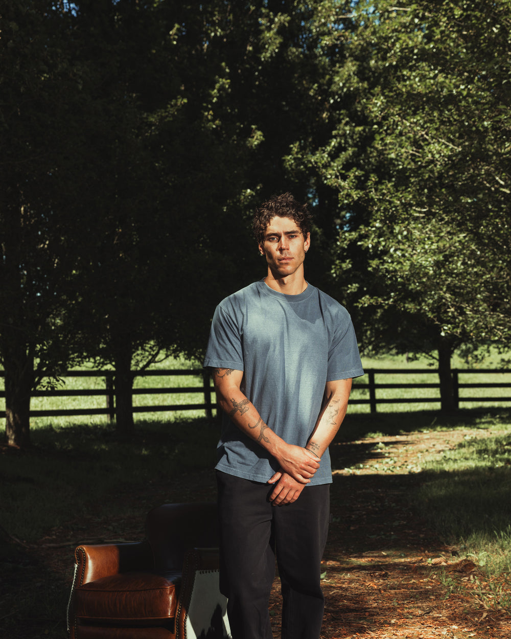 image of Unisex Faded T-shirt : Male model wearing an American Apparel Garment Dyed Heavyweight Cotton Tee Shirt in Faded Navy, paired with light blue jeans, standing against a plain background (front pose) -Navy