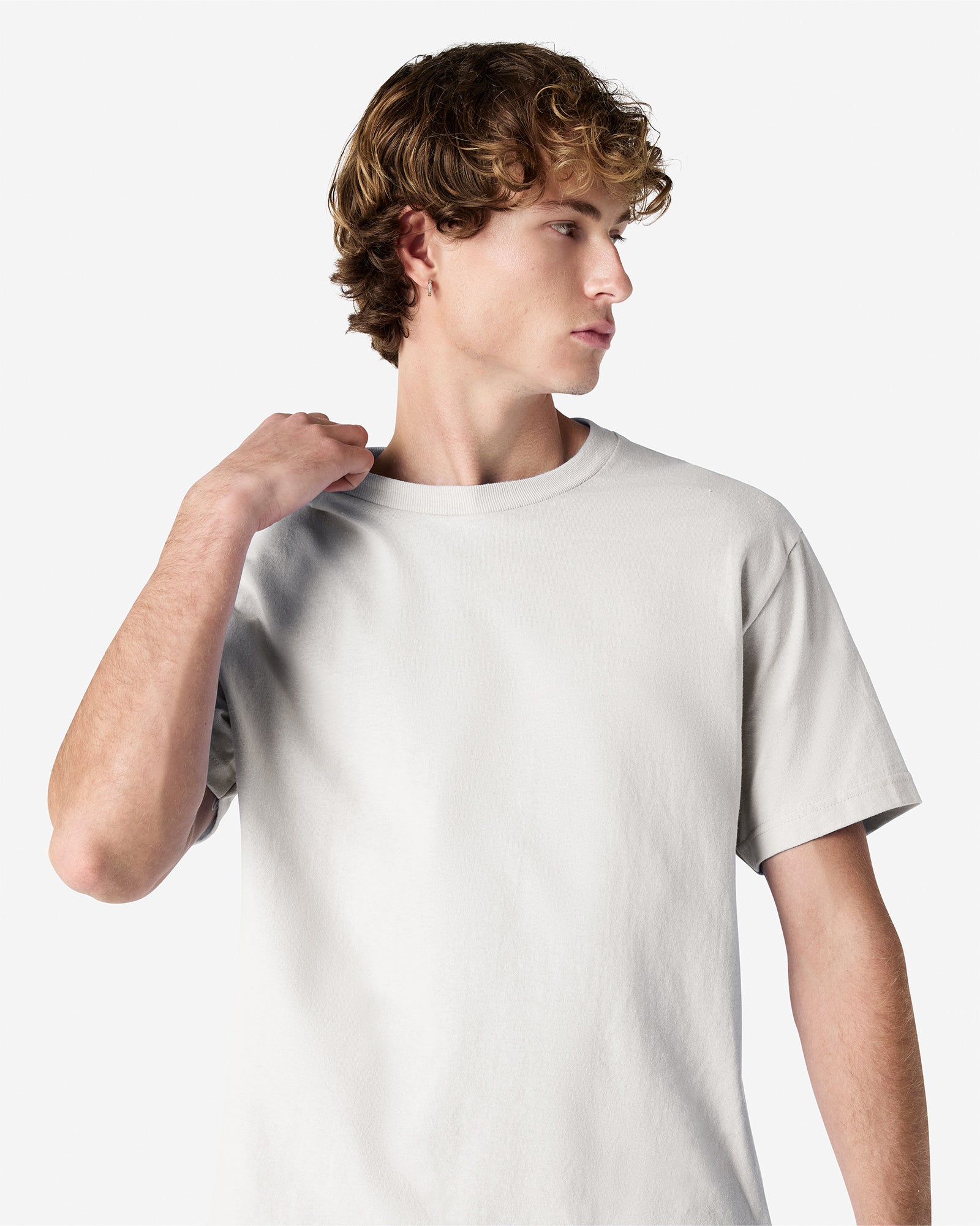 Male Model wearing a Ash Heavyweight Unisex Short Sleeve Crew Neck Tee, paired with blue jeans, standing against a plain background (front pose) -ash