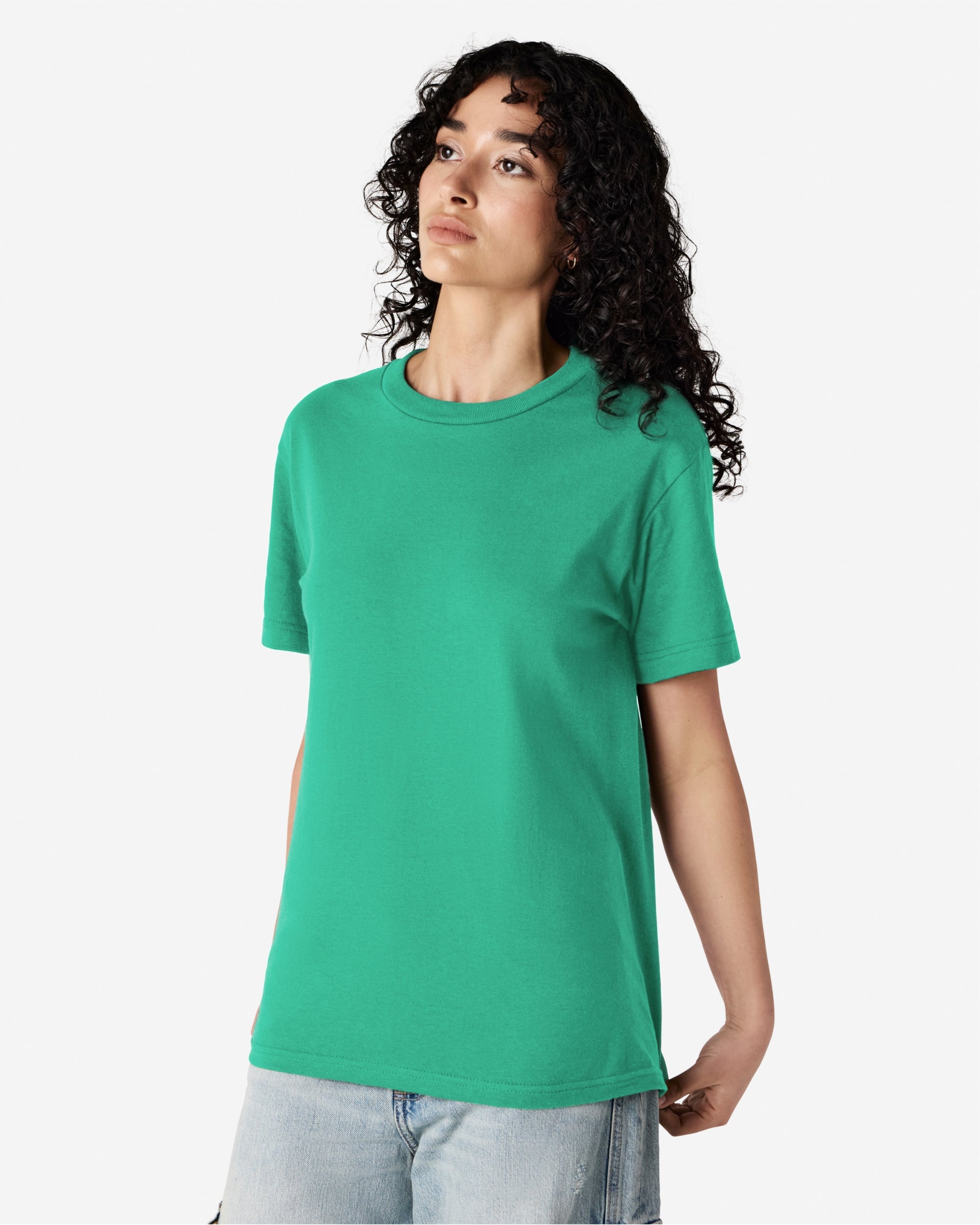 Female Model wearing a Celadon Heavyweight Unisex Short Sleeve Crew Neck Tee, paired with blue jeans, standing against a plain background (front pose) -celadon