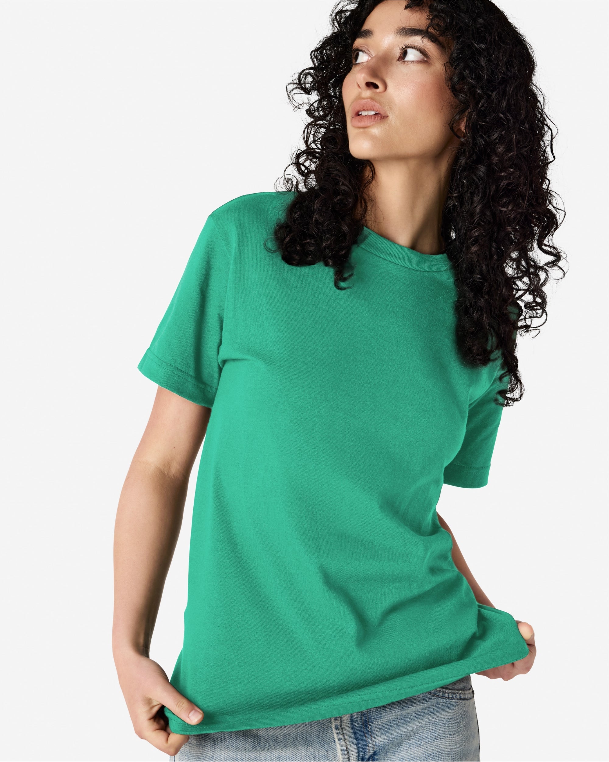 Female Model wearing a Celadon Heavyweight Unisex Short Sleeve Crew Neck Tee, paired with blue jeans, standing against a plain background (front pose) -celadon