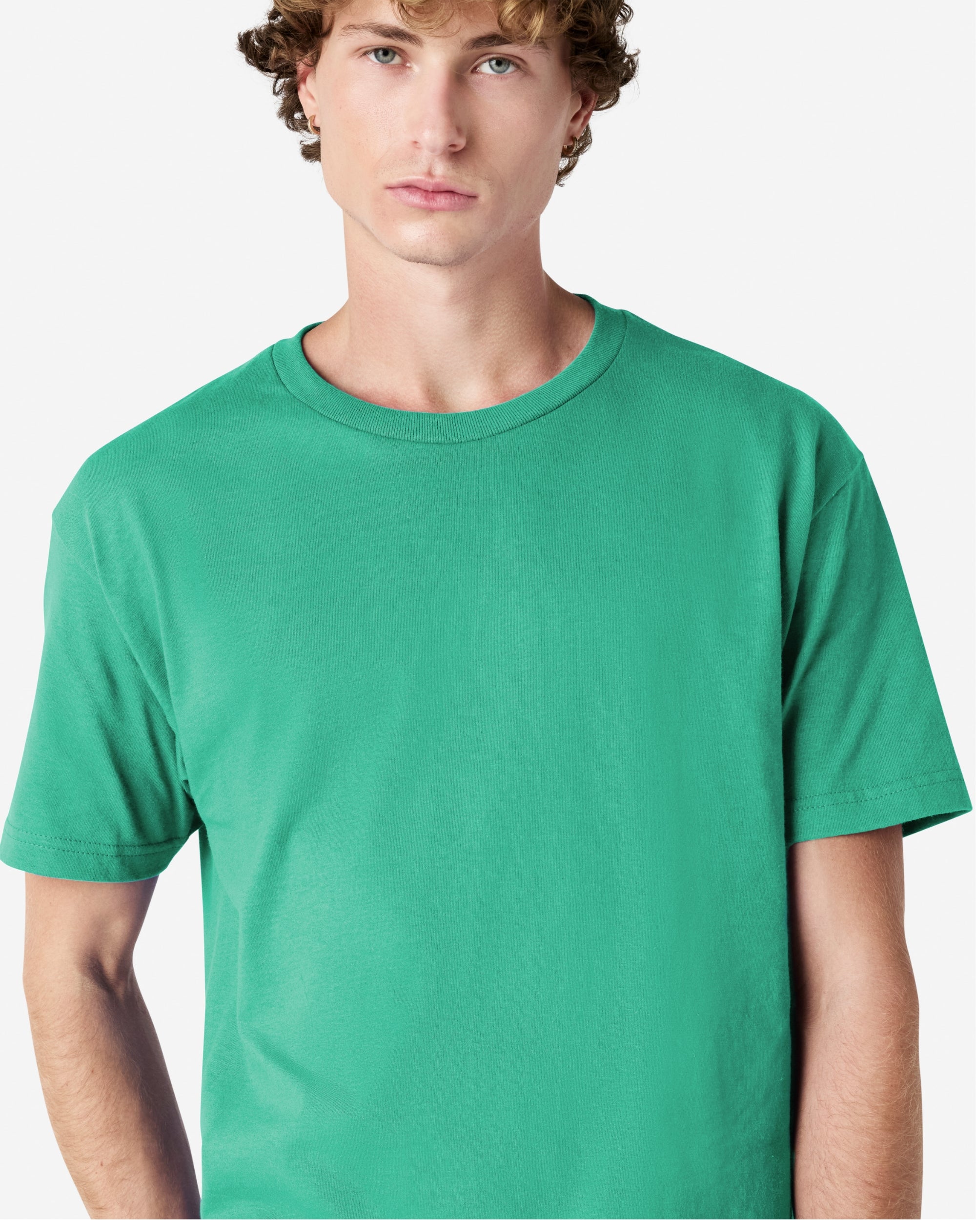 Male Model wearing a Celadon Heavyweight Unisex Short Sleeve Crew Neck Tee, paired with blue jeans, standing against a plain background (front pose) -celadon