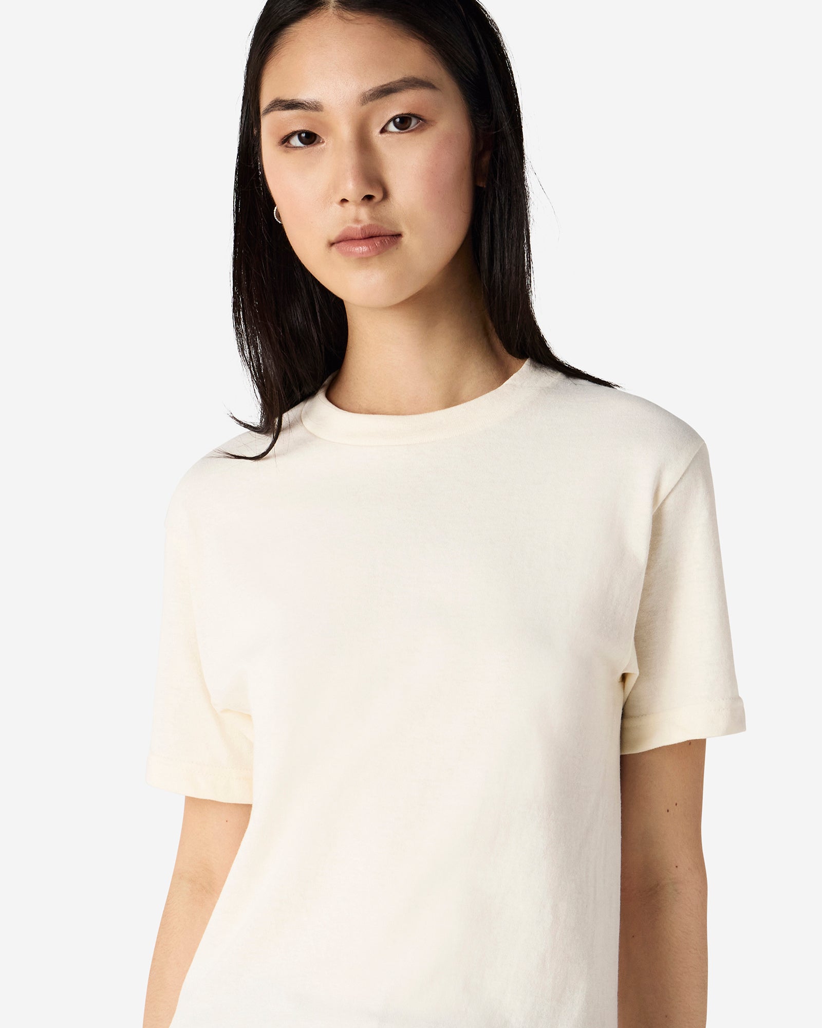 Male Model wearing a Cream Heavyweight Unisex Short Sleeve Crew Neck Tee, paired with blue jeans, standing against a plain background (front pose) -cream