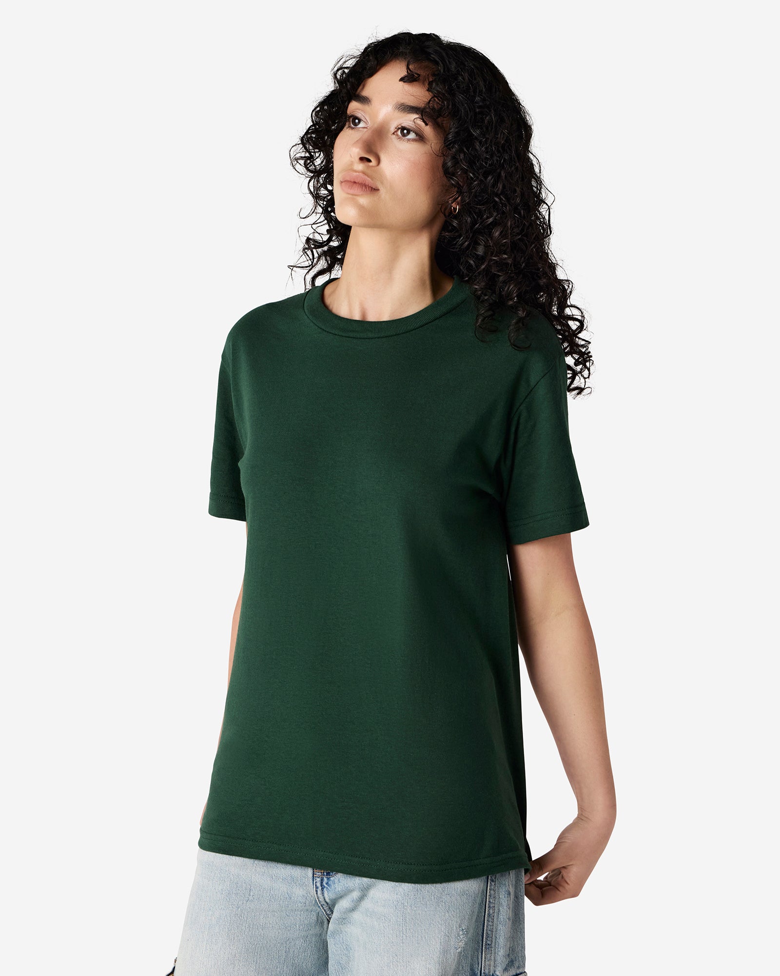 Female Model wearing a Forest Heavyweight Unisex Short Sleeve Crew Neck Tee, paired with blue jeans, standing against a plain background (front pose) -forest green