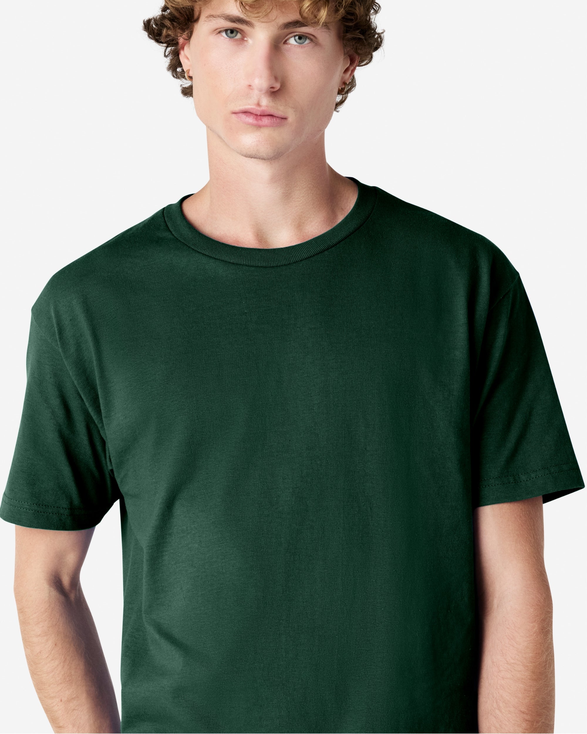 Male Model wearing a Forest Heavyweight Unisex Short Sleeve Crew Neck Tee, paired with blue jeans, standing against a plain background (front pose) -forest green