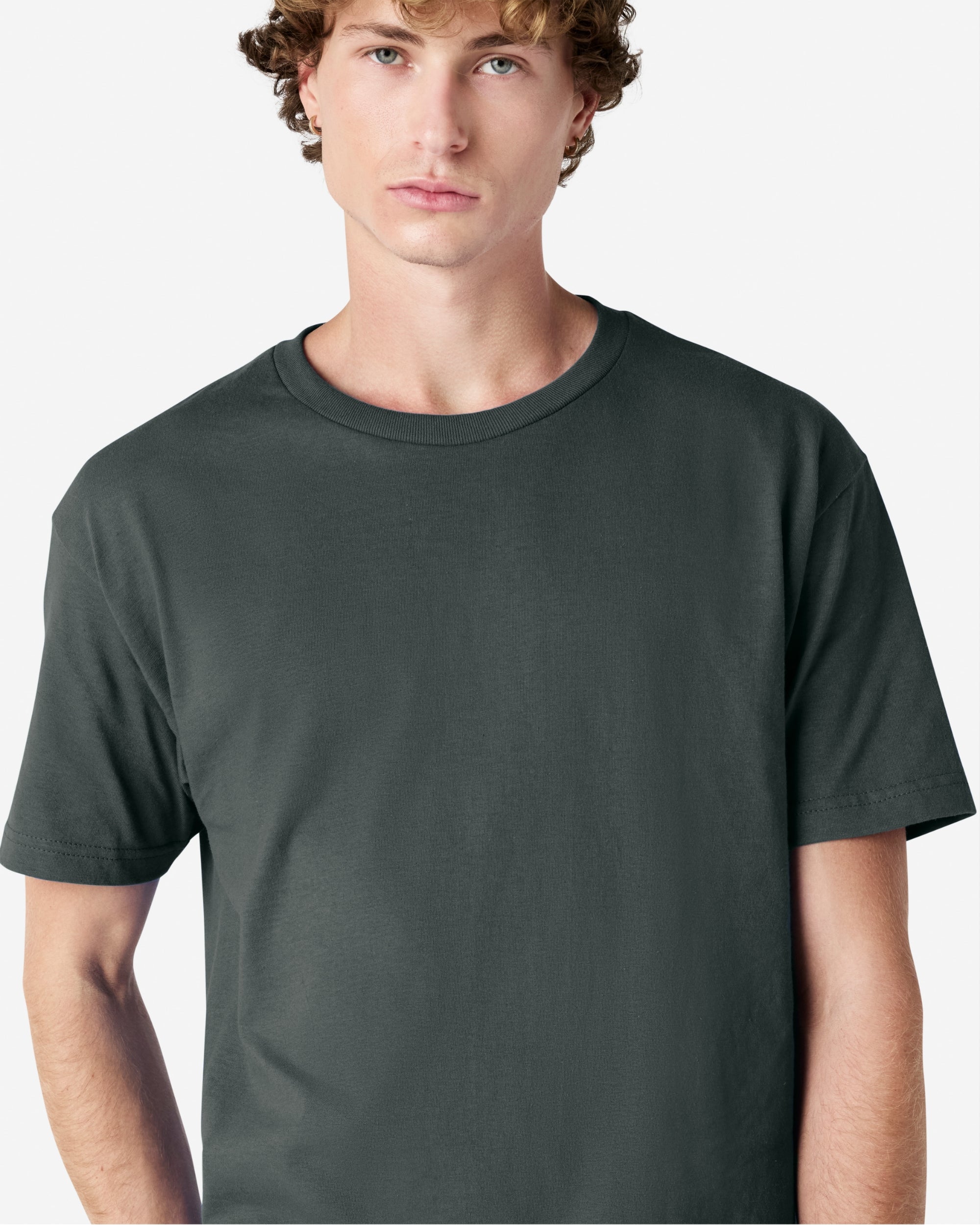 Male Model wearing a Heather Charcoal Heavyweight Unisex Short Sleeve Crew Neck Tee, paired with blue jeans, standing against a plain background (front pose) -heather charcoal