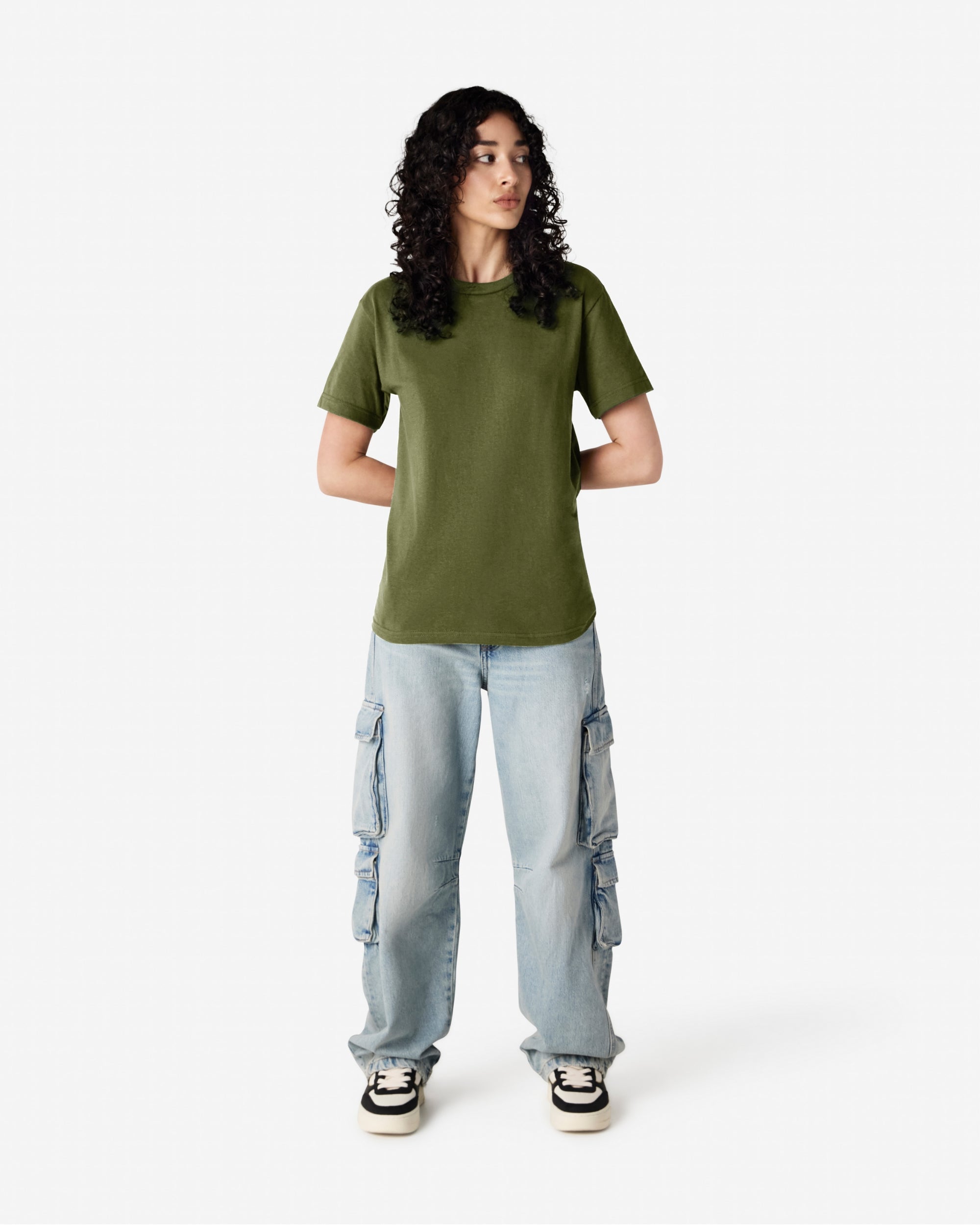 Female Model wearing a Military Green Heavyweight Unisex Short Sleeve Crew Neck Tee, paired with blue jeans, standing against a plain background (front pose) -military green