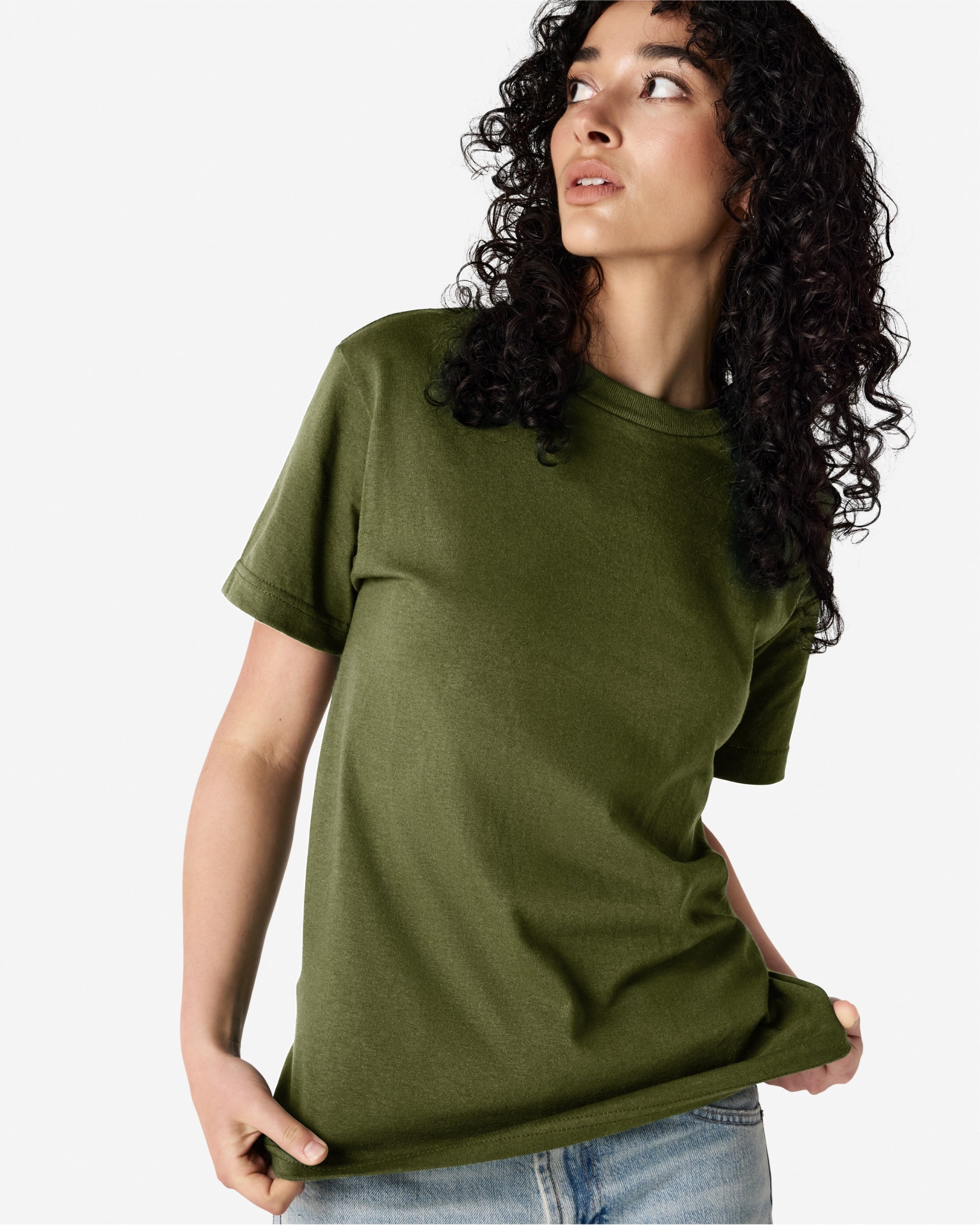 Female Model wearing a Military Green Heavyweight Unisex Short Sleeve Crew Neck Tee, paired with blue jeans, standing against a plain background (front pose) -military green