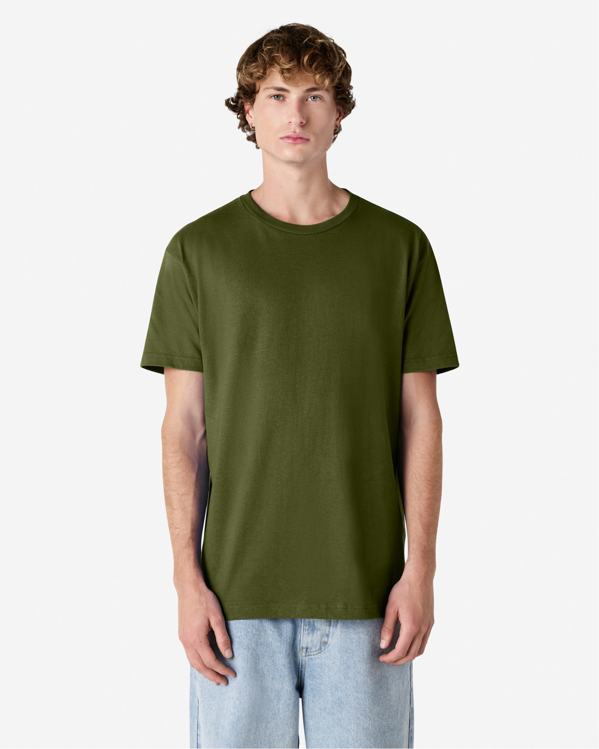 Male Model wearing a Military Green Heavyweight Unisex Short Sleeve Crew Neck Tee, paired with blue jeans, standing against a plain background (front pose) -military green