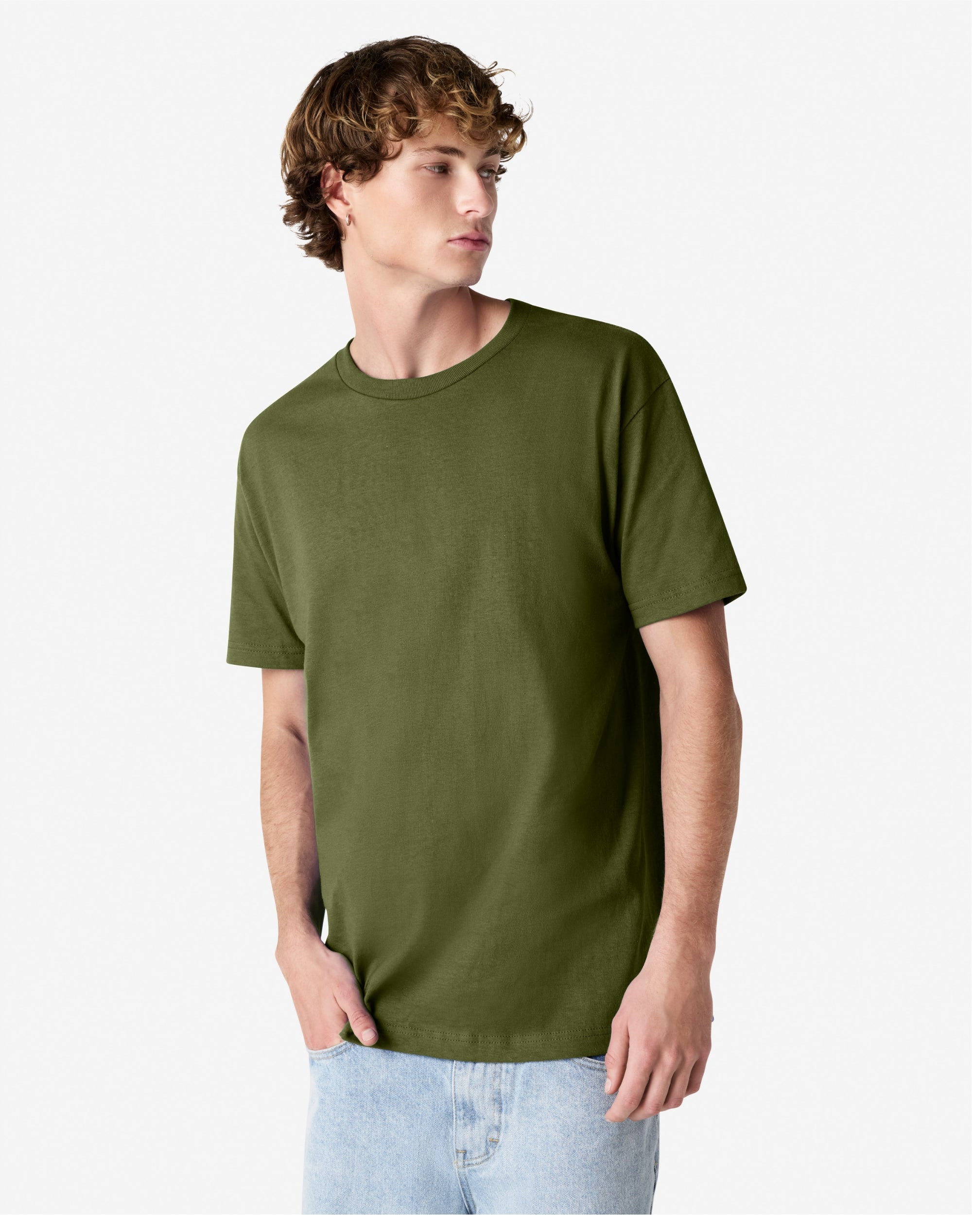 Male Model wearing a Military Green Heavyweight Unisex Short Sleeve Crew Neck Tee, paired with blue jeans, standing against a plain background (front pose) -military green
