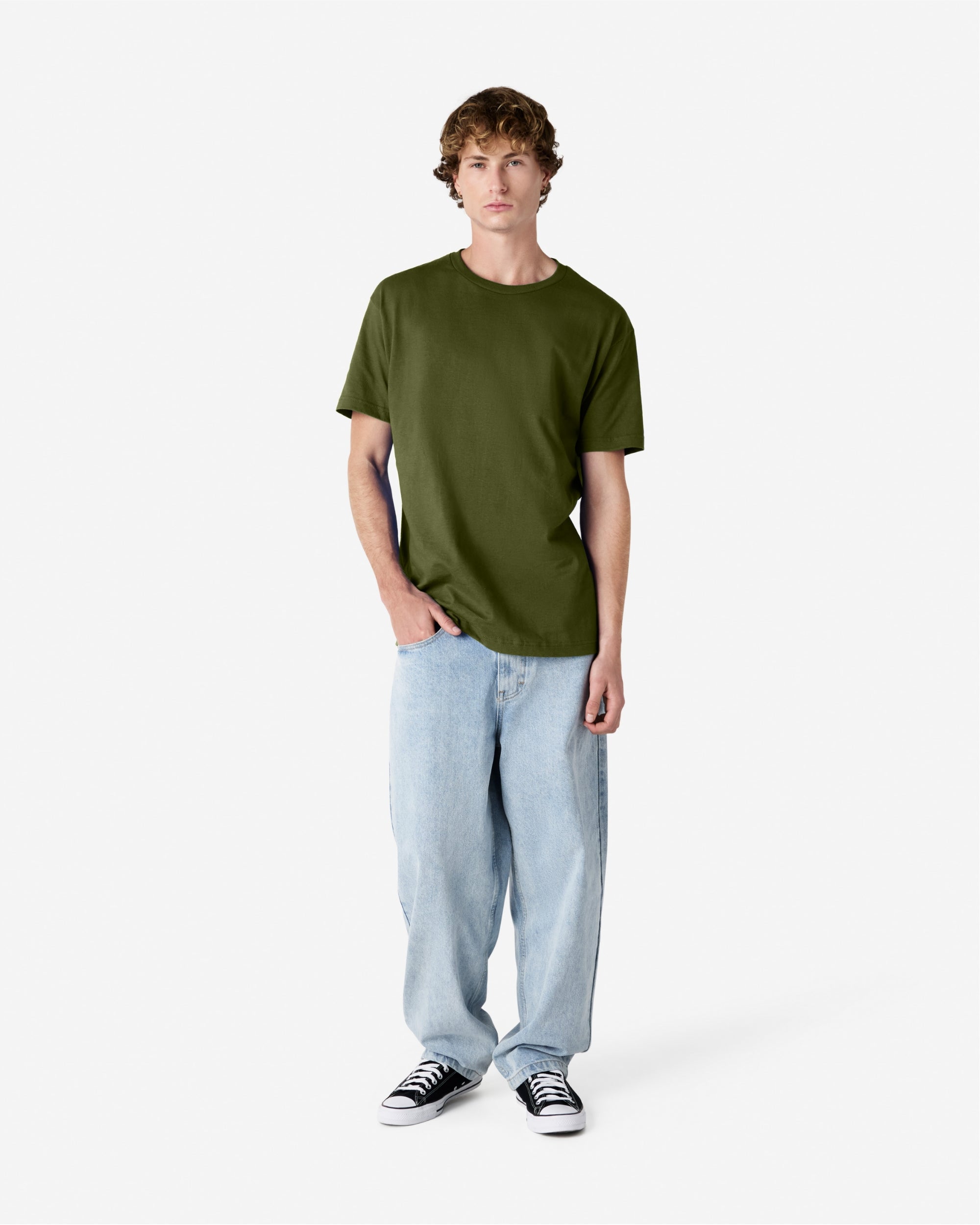 Male Model wearing a Military Green Heavyweight Unisex Short Sleeve Crew Neck Tee, paired with blue jeans, standing against a plain background (front pose) -military green