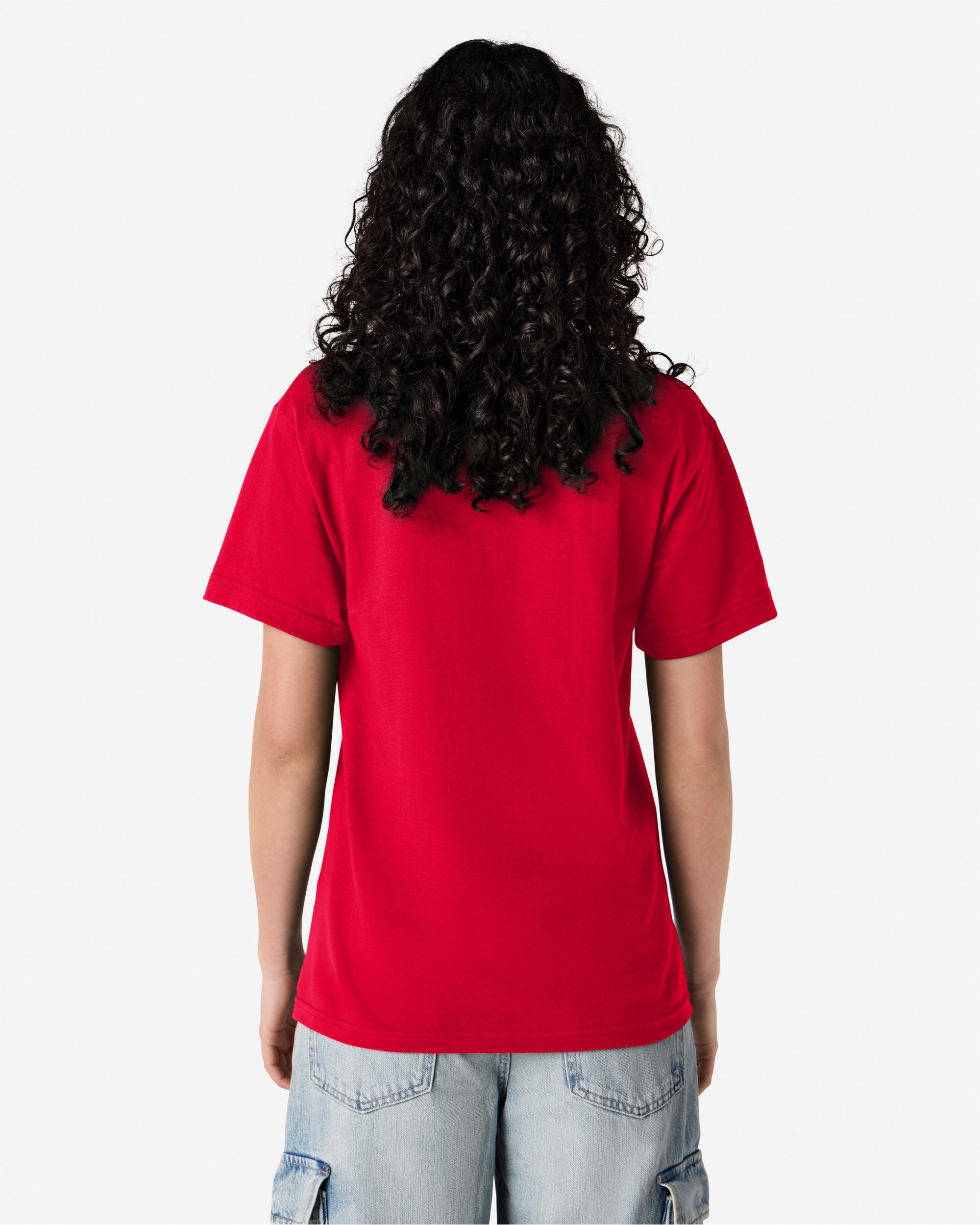 Female Model wearing a red Heavyweight Unisex Short Sleeve Crew Neck Tee, paired with blue jeans, standing against a plain background (back pose) -red