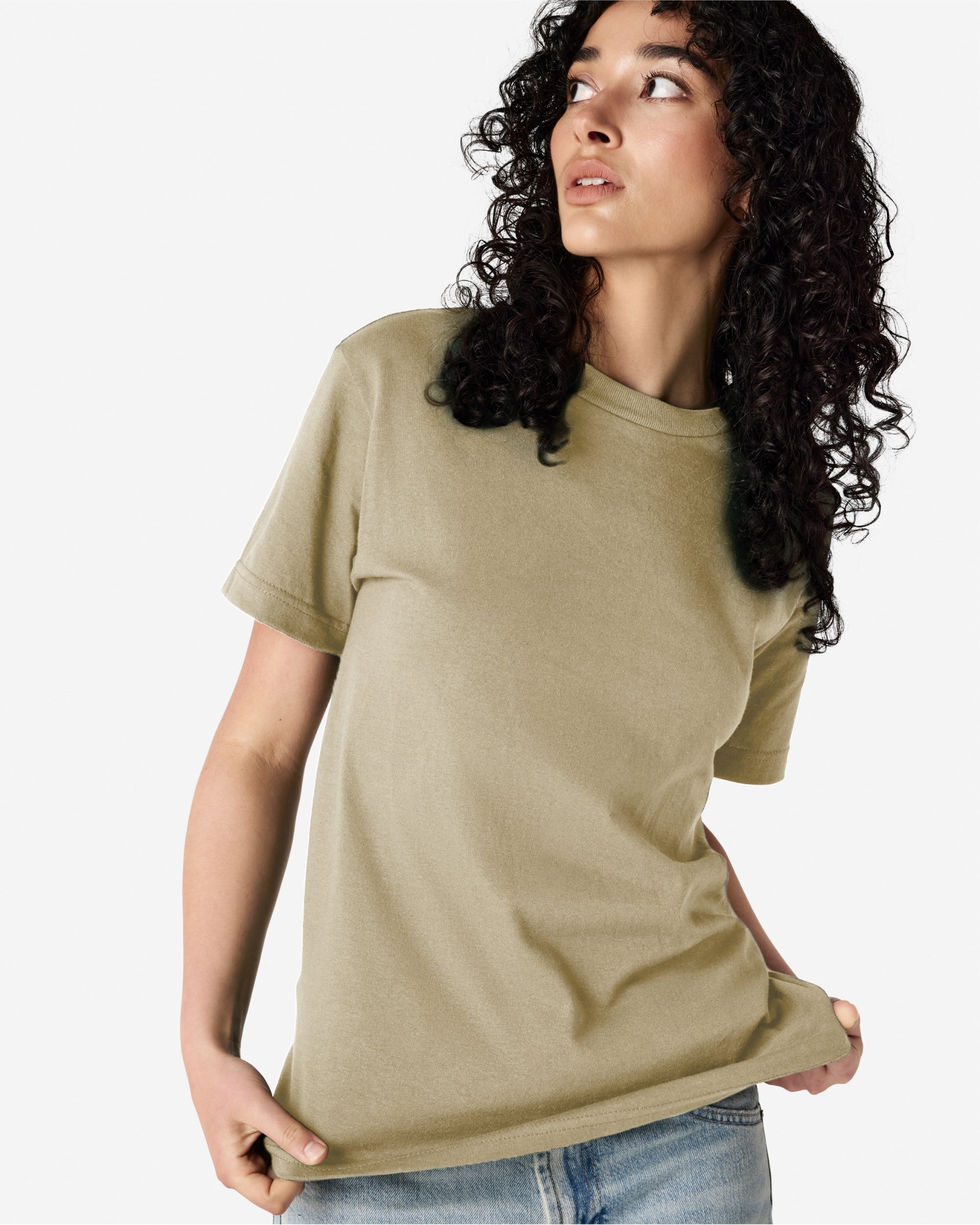 Female Model wearing a Sand Heavyweight Unisex Short Sleeve Crew Neck Tee, paired with blue jeans, standing against a plain background (front pose) -sand