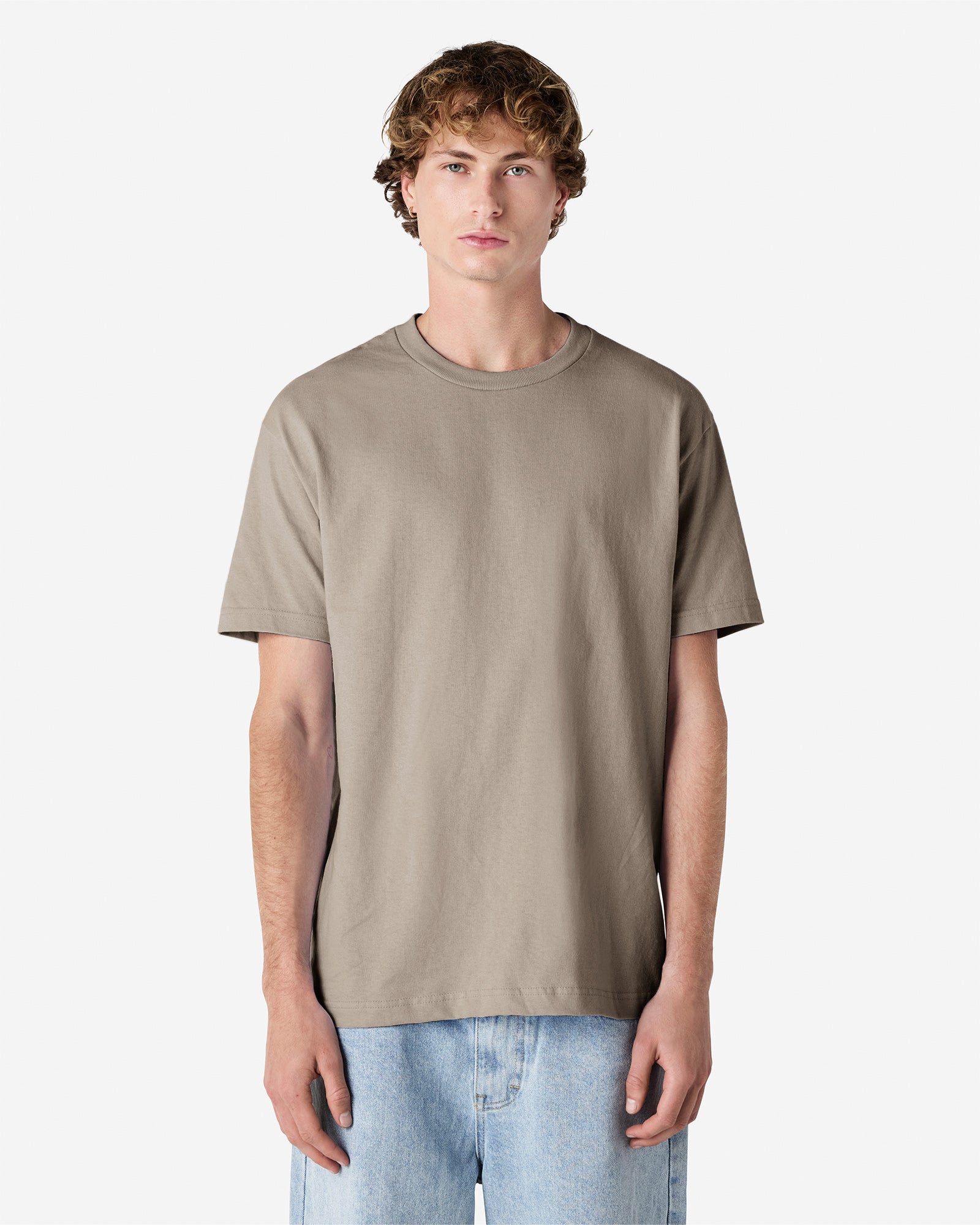 Male Model wearing a Slate Heavyweight Unisex Short Sleeve Crew Neck Tee, paired with blue jeans, standing against a plain background (front pose) -Slate